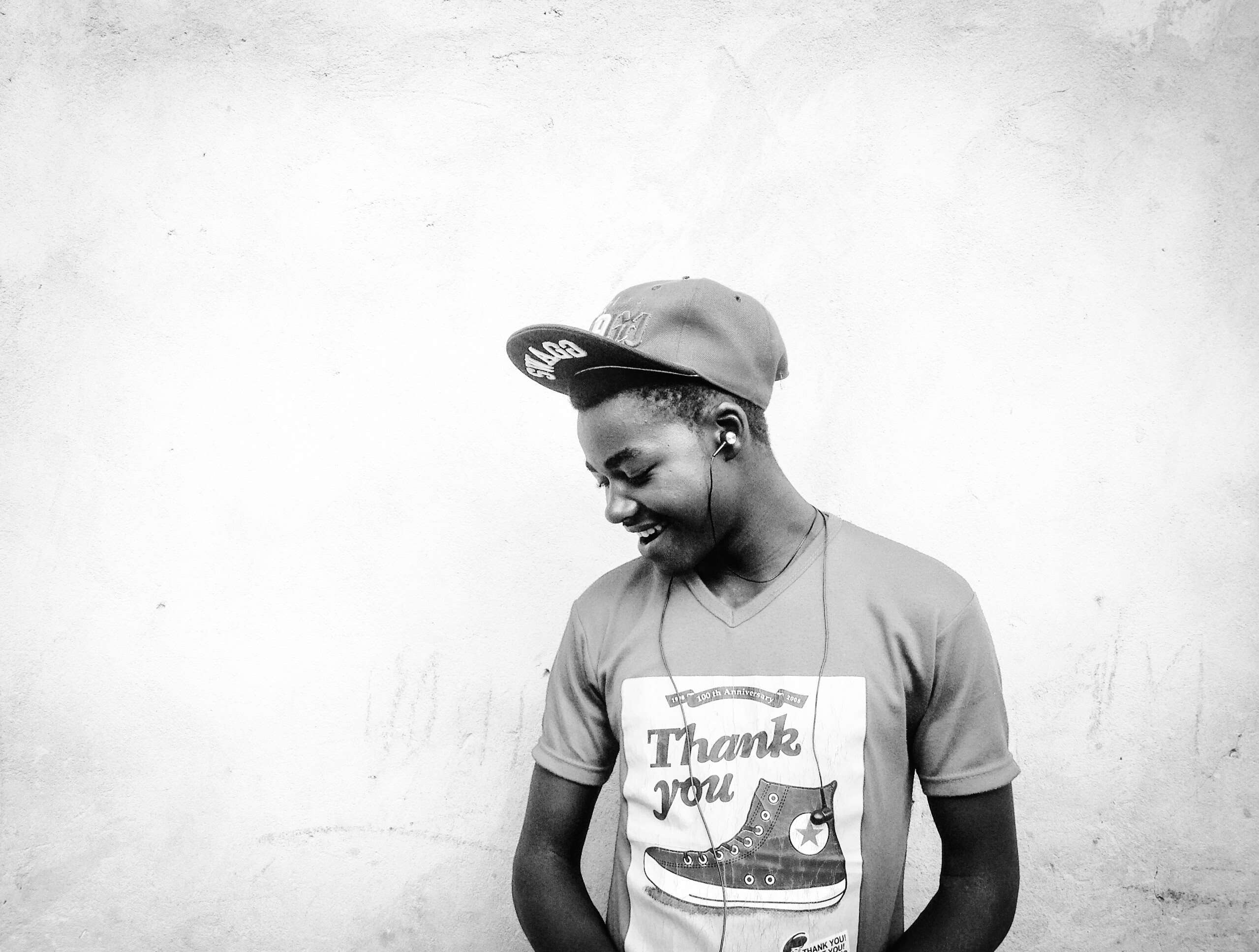 Young Black man wearing a cap and headphones HD Wallpaper