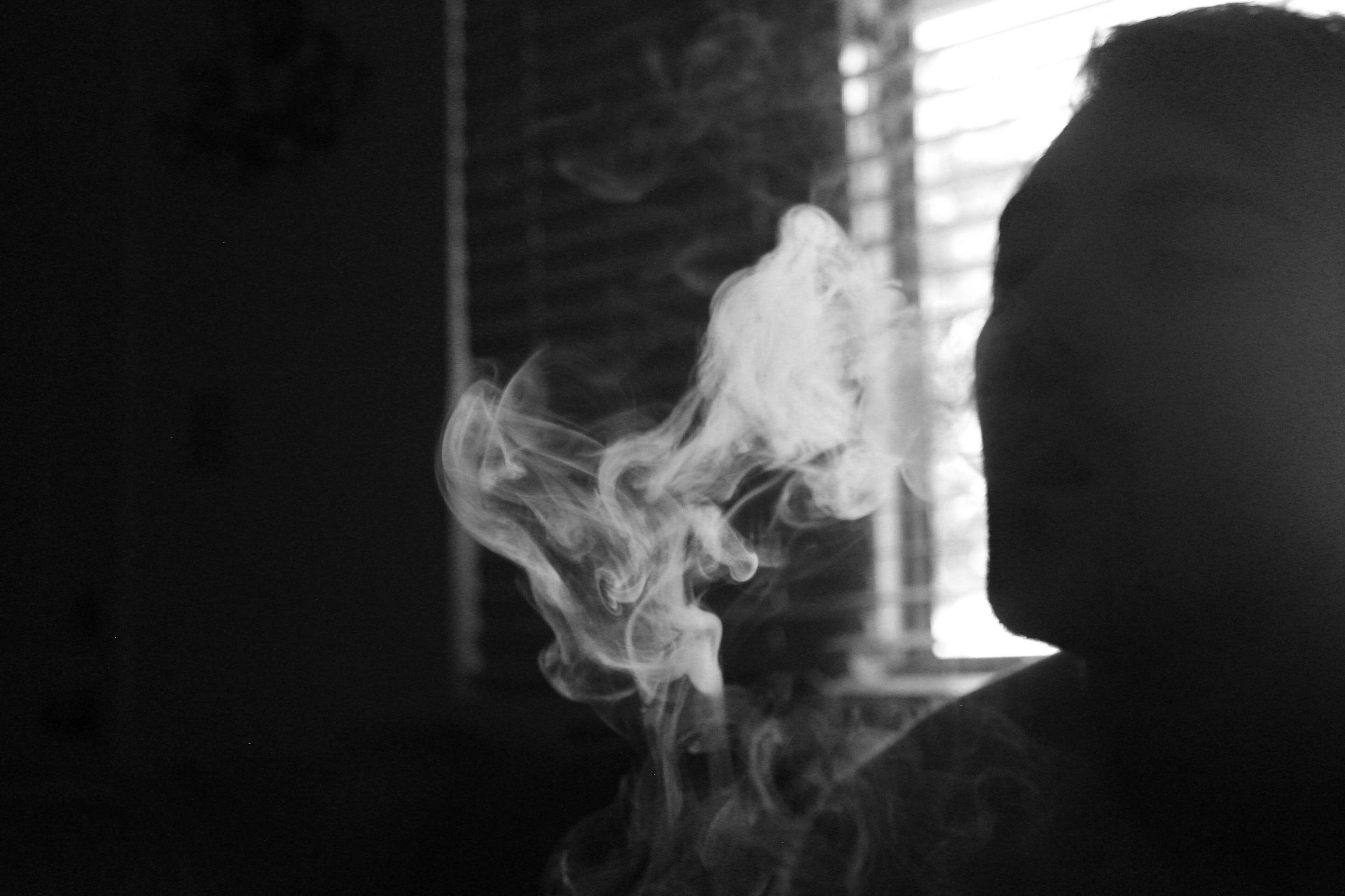 Man exhaling smoke in black and white 4K HD Wallpaper