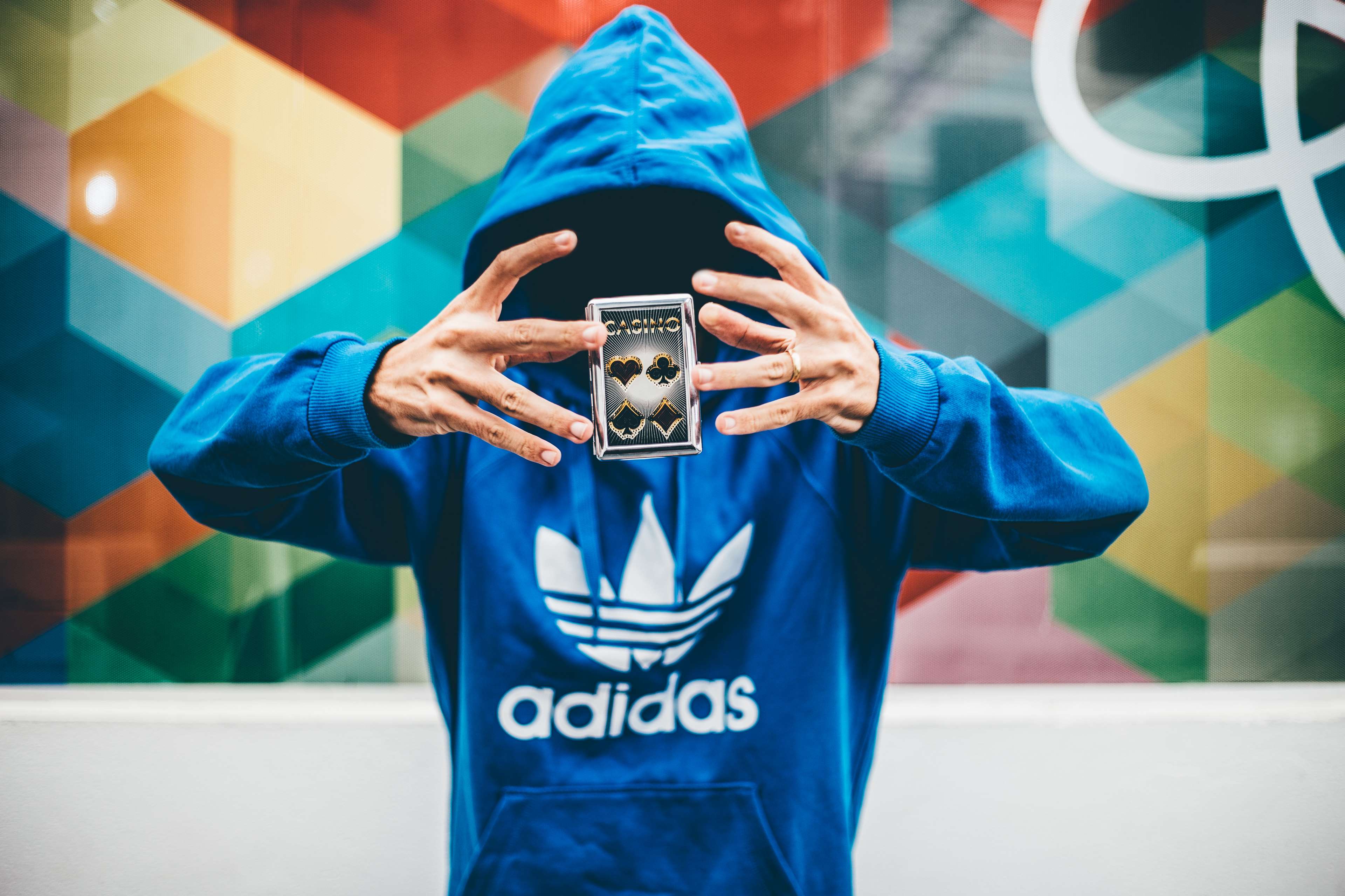Man in Adidas hoodie levitating a casino card HD Wallpaper
