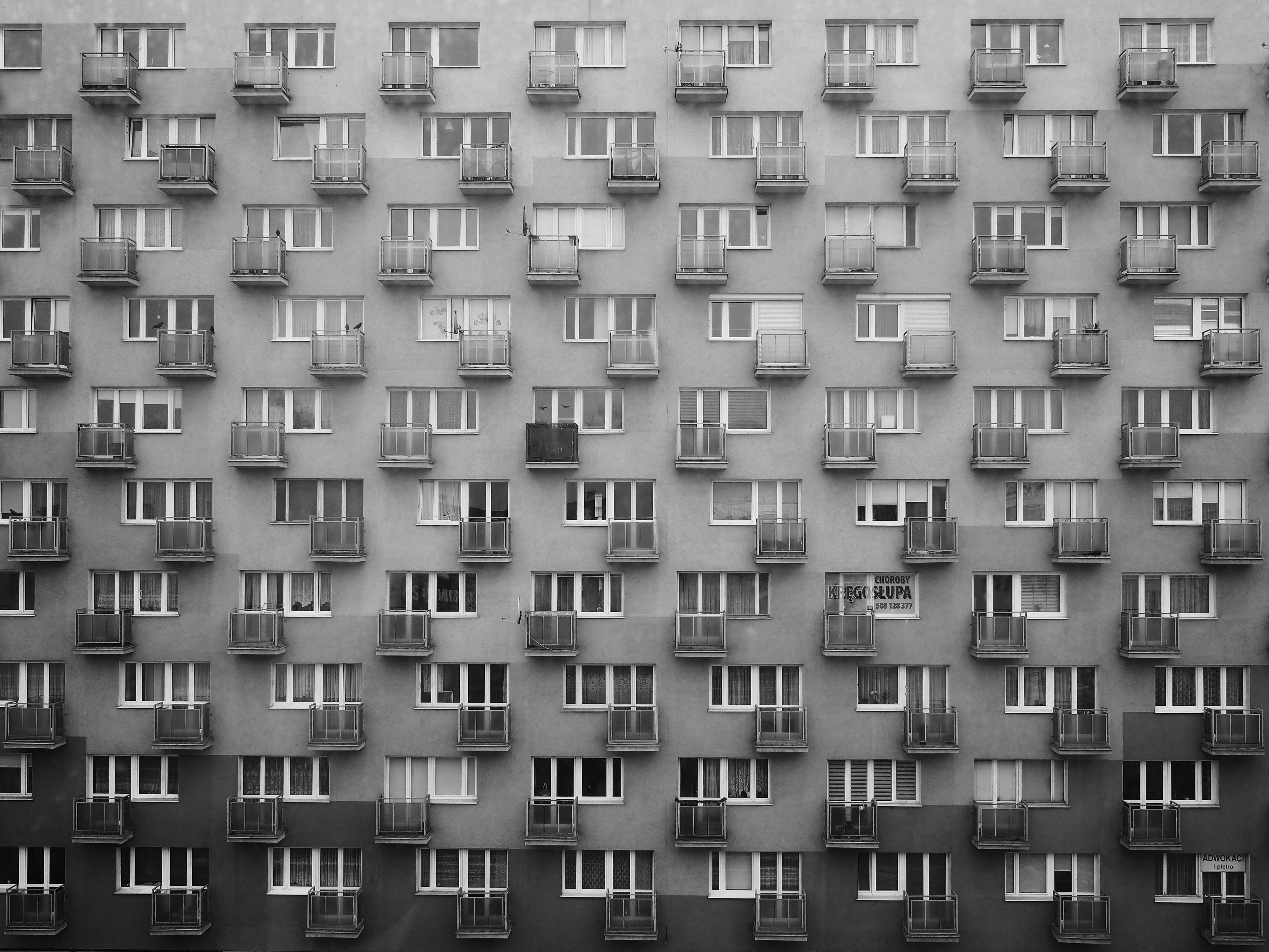 Black and white image of a block of flats with balconies and windows HD Wallpaper