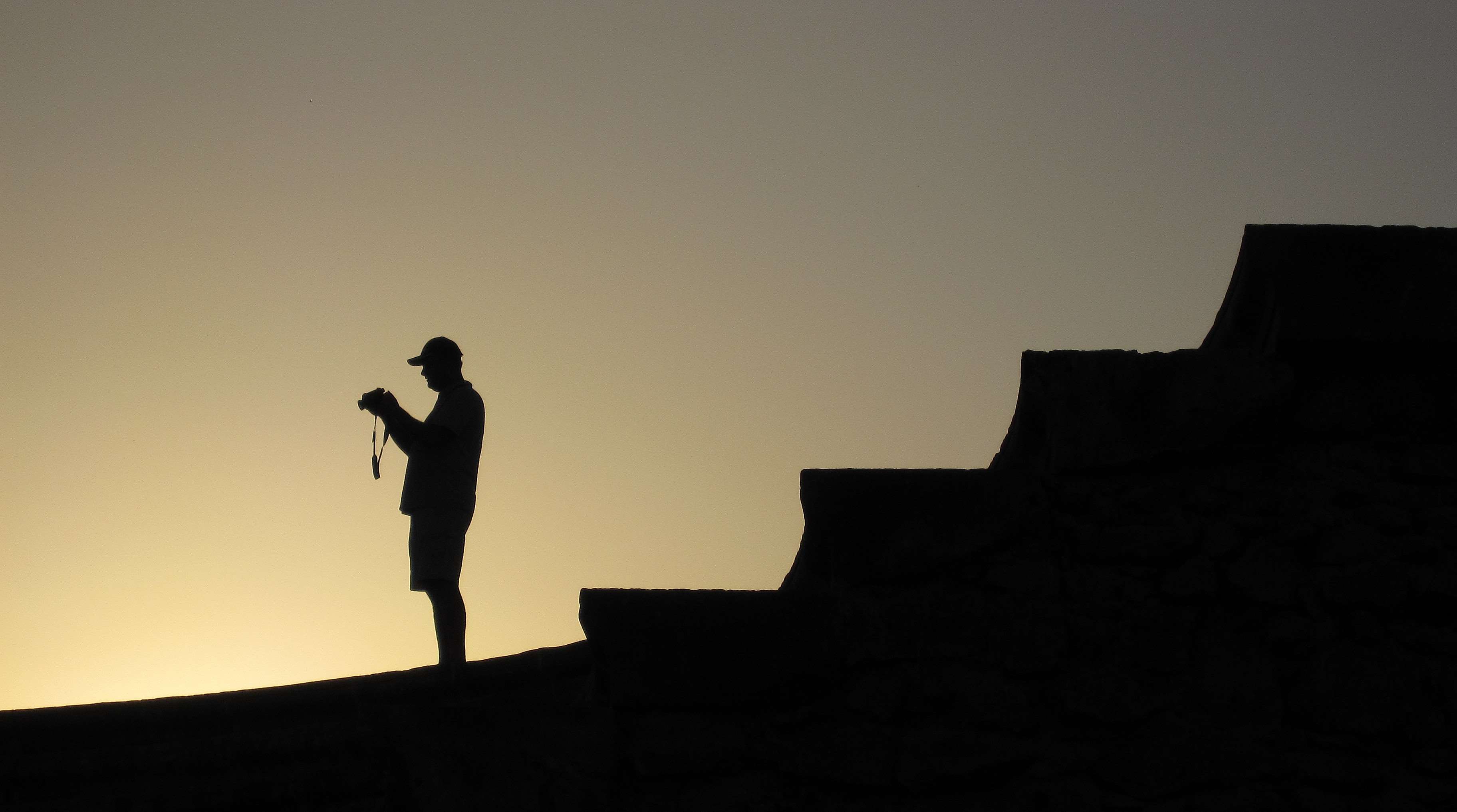 Silhouette of a photographer on stairs at sunset HD Wallpaper