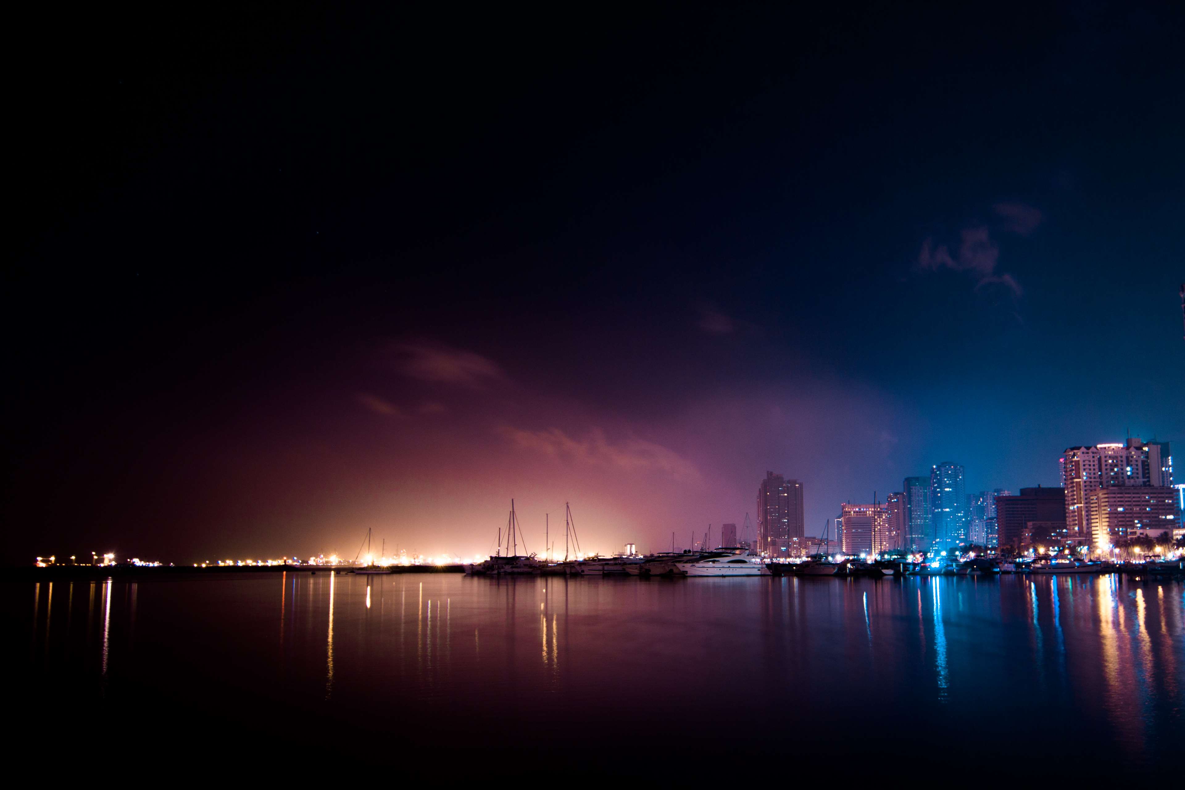 Cityscape with boats and lights at night HD Wallpaper