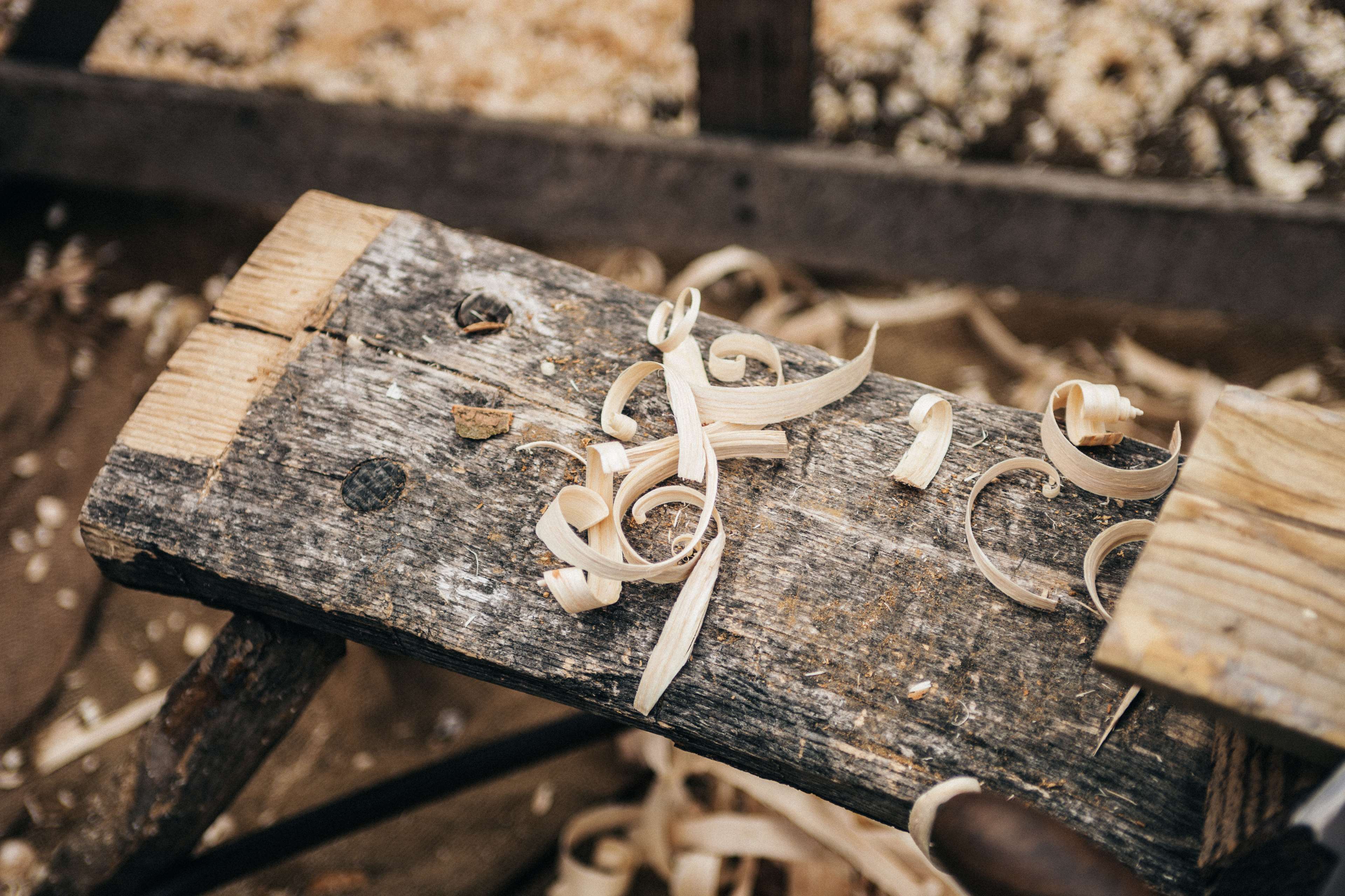 Wood shavings on a weathered workbench HD Wallpaper