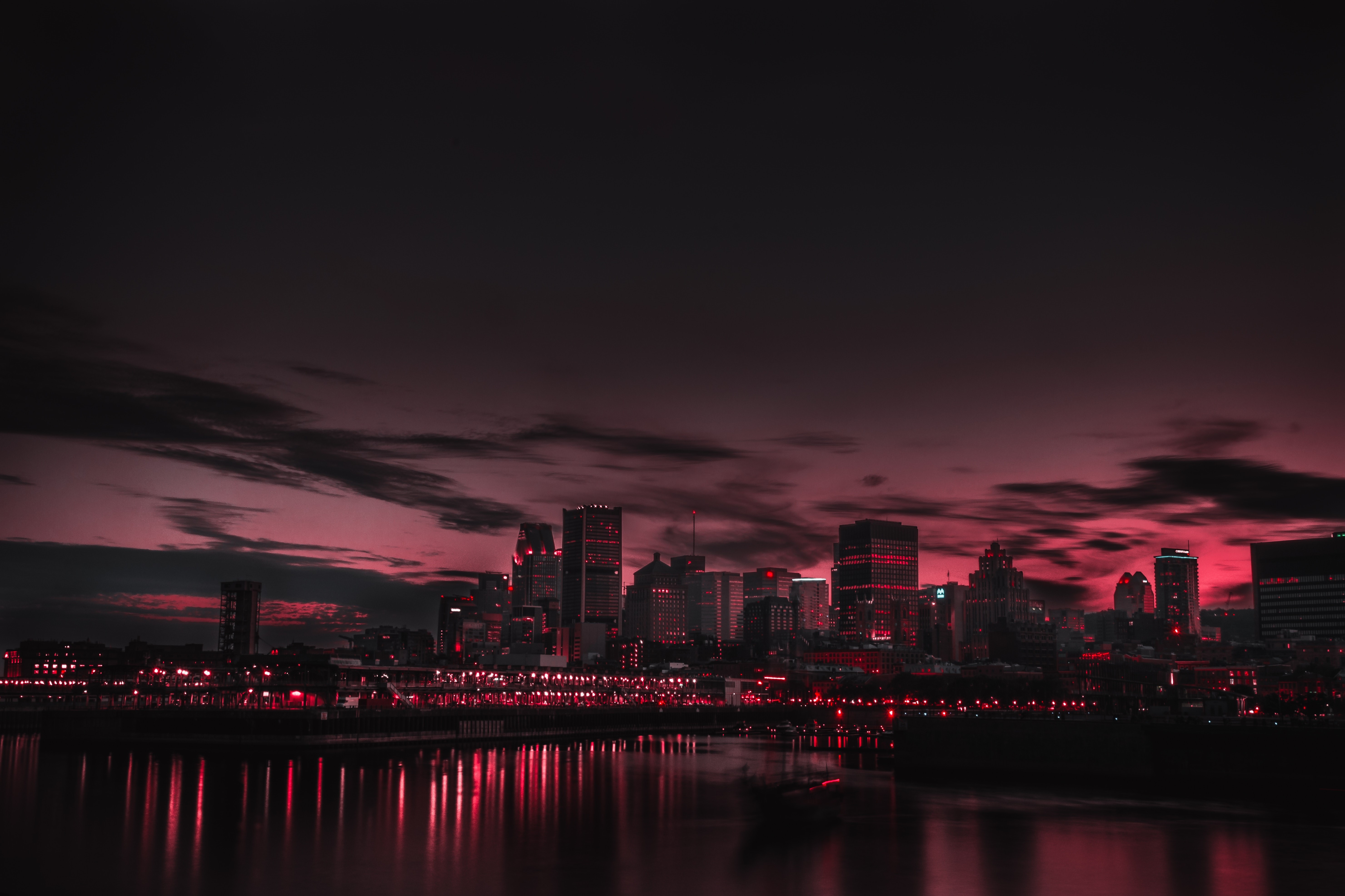 City skyline at night with red lights and reflections HD Wallpaper