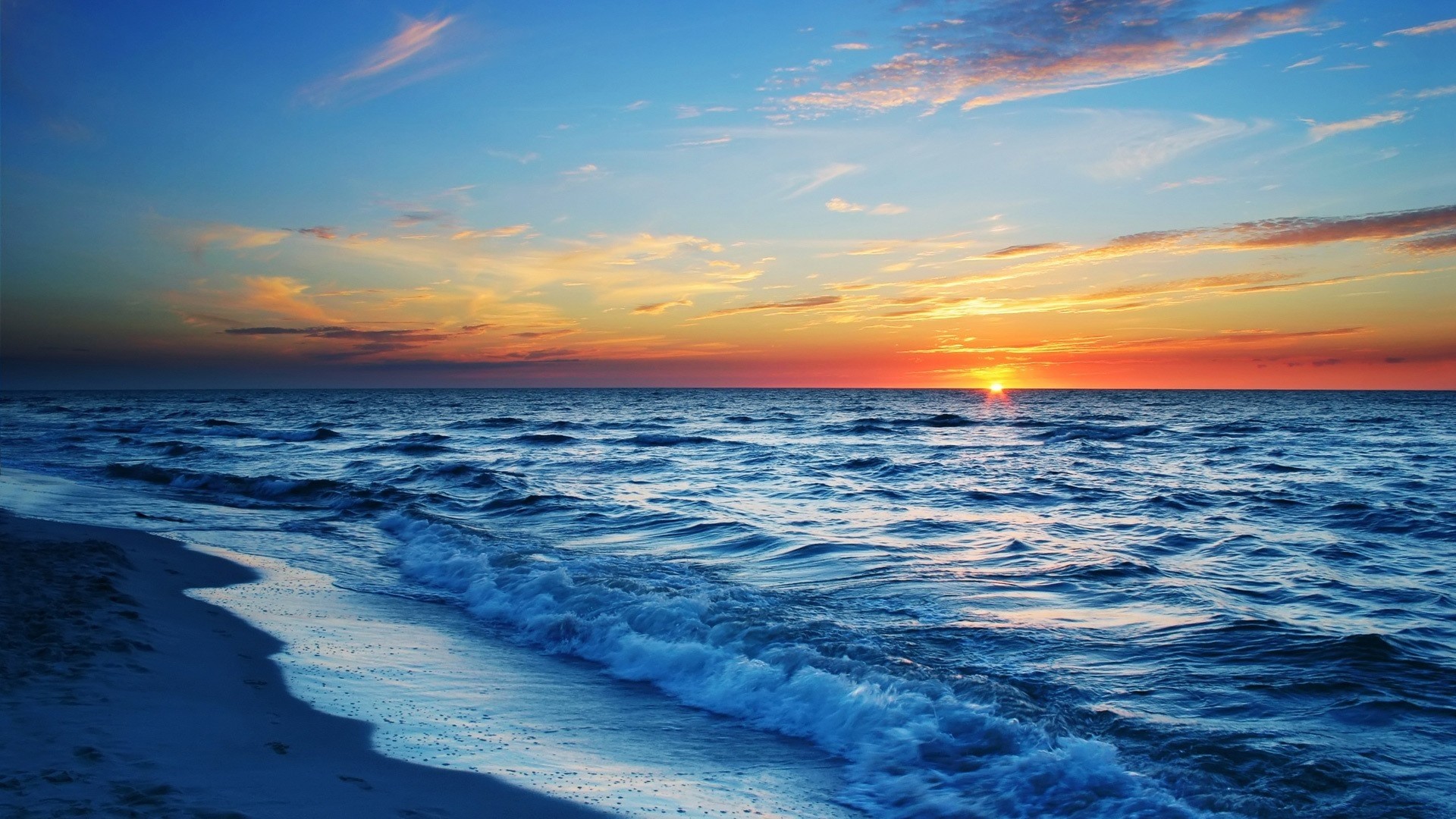 Sunset over the ocean with waves and beach HD Wallpaper