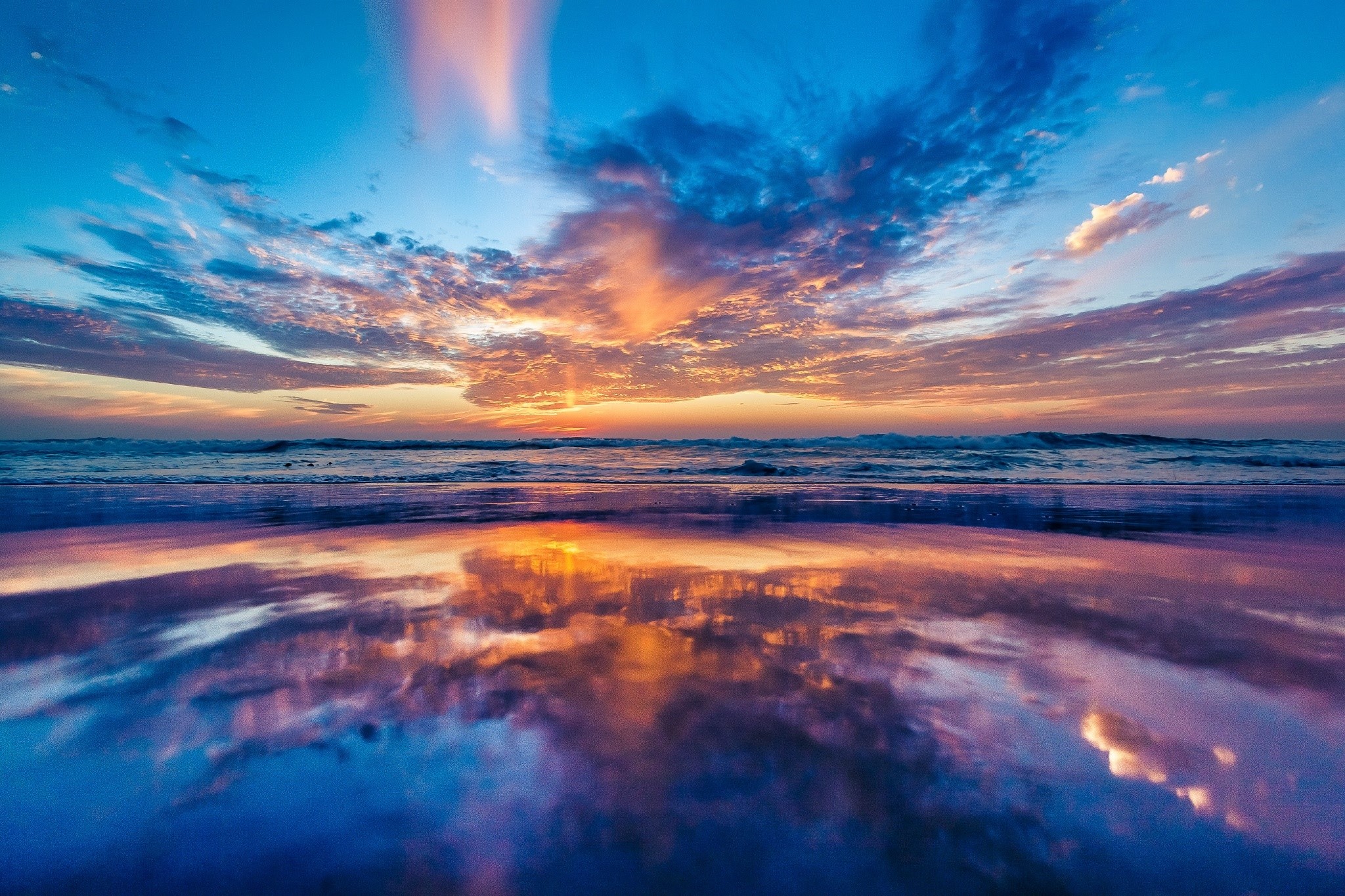 Sunset over the ocean with reflection on the beach HD Wallpaper
