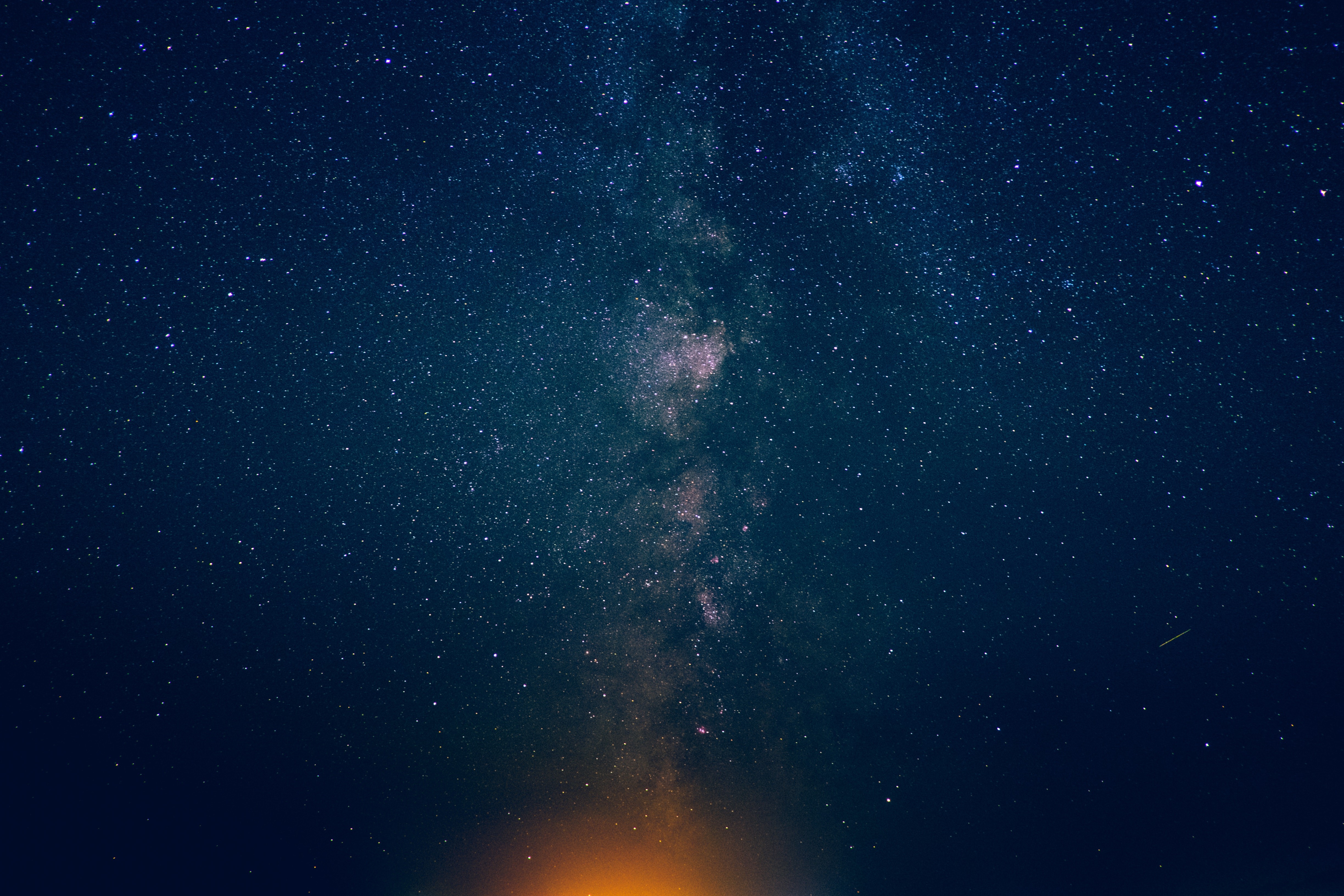 Milky Way galaxy with stars and orange light HD Wallpaper
