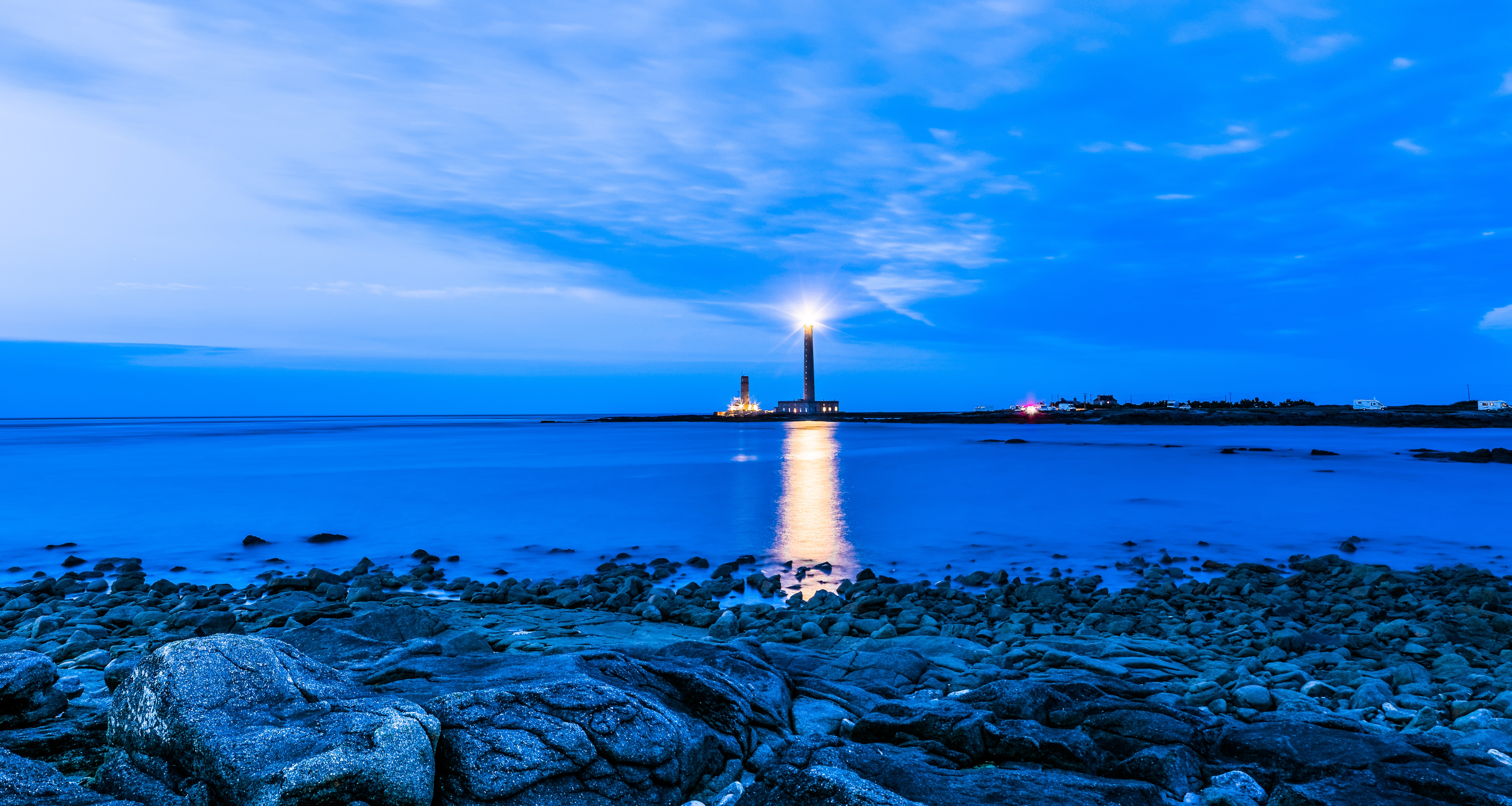 Lighthouse on the rocky shore at dusk HD Wallpaper
