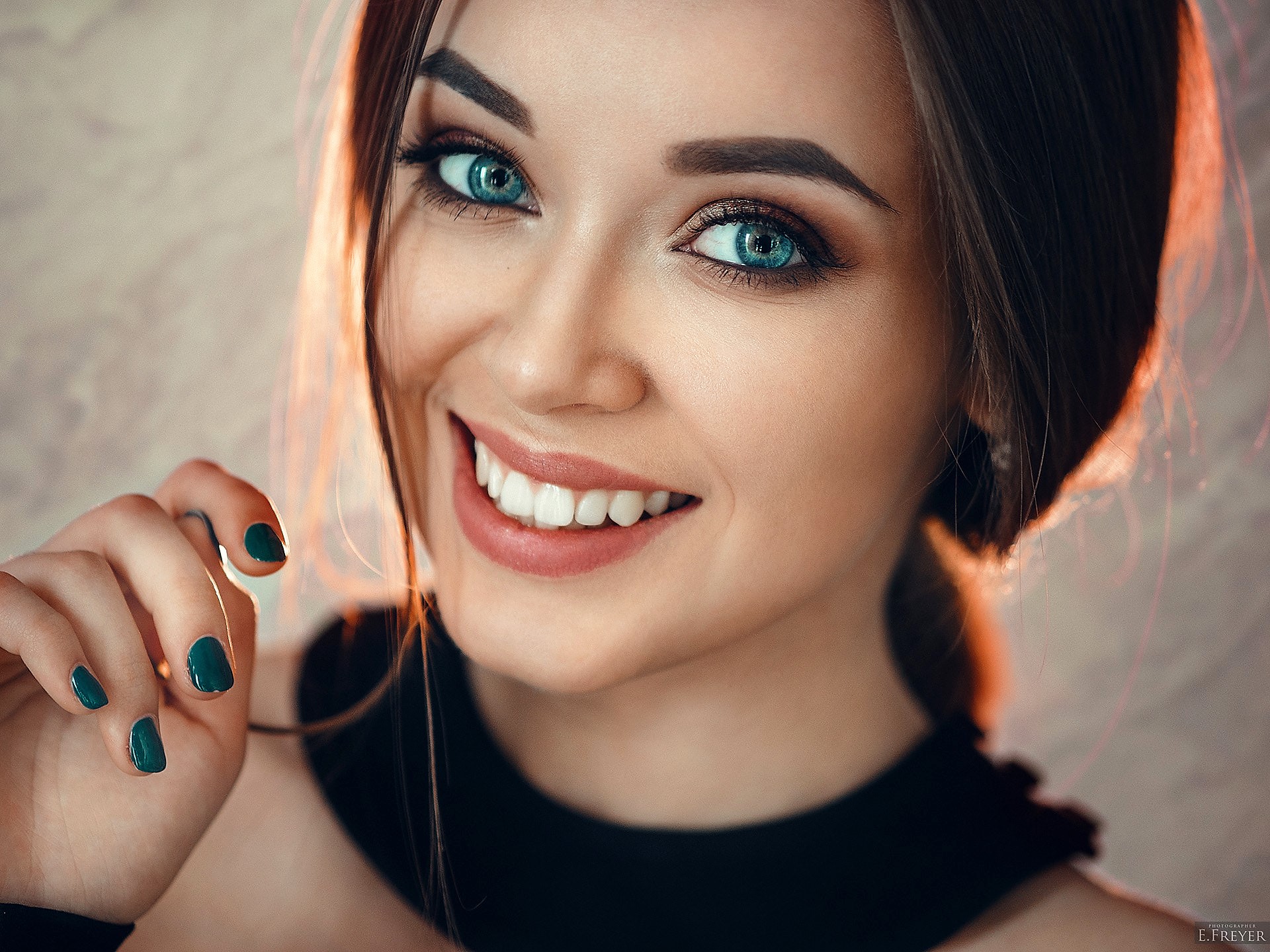 Smiling Woman with Blue Eyes and Dark Nail Polish HD Wallpaper