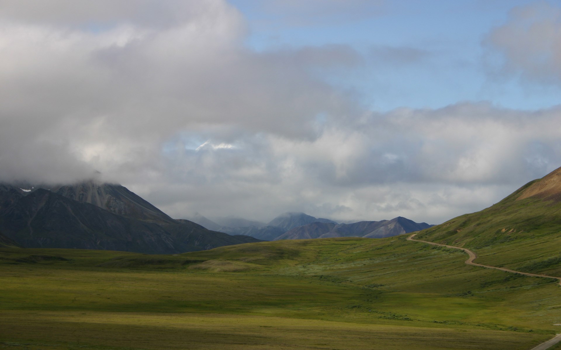 Mountain landscape with clouds and a winding road HD Wallpaper
