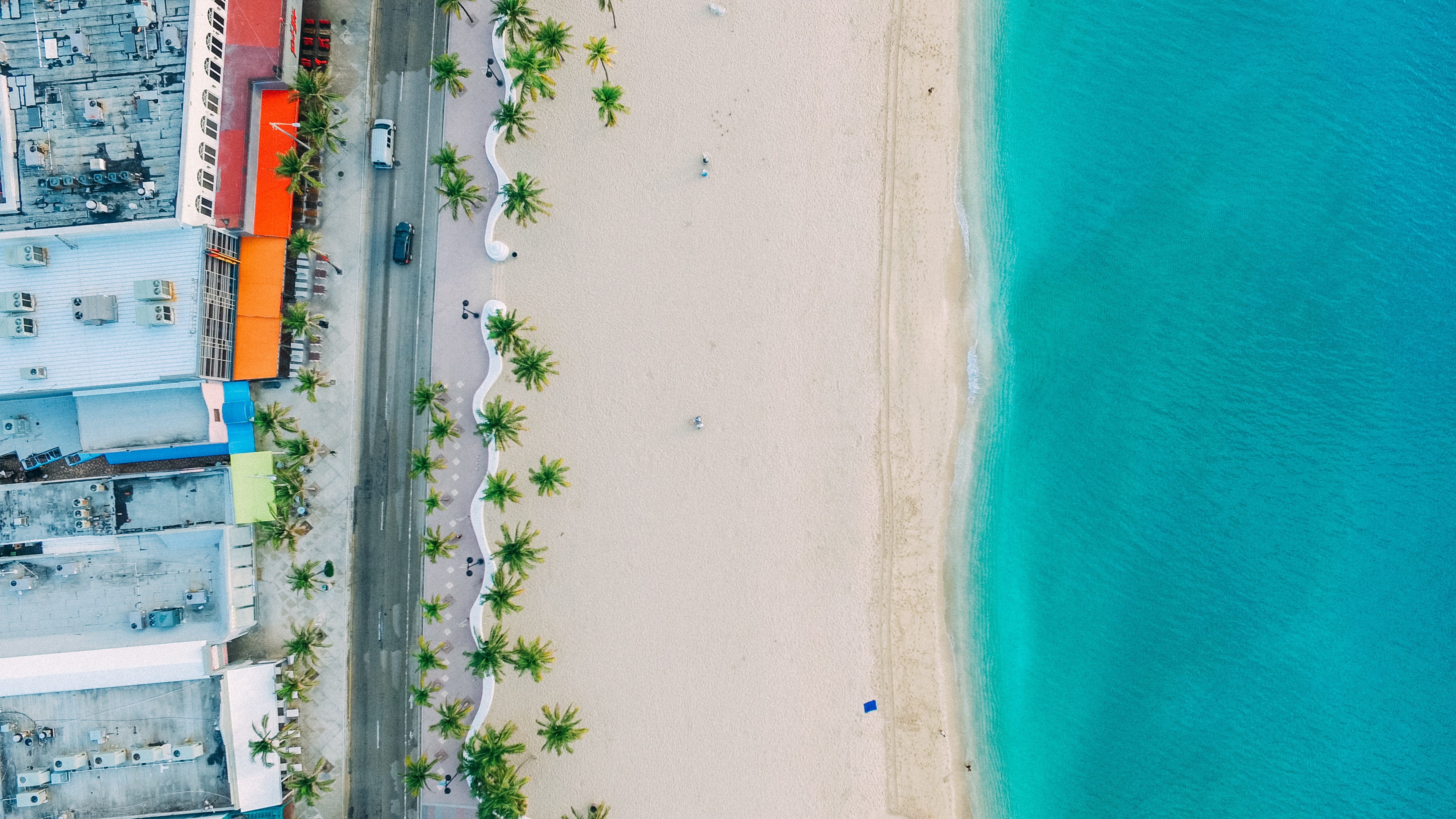 Aerial view of a beach with buildings and palm trees HD Wallpaper
