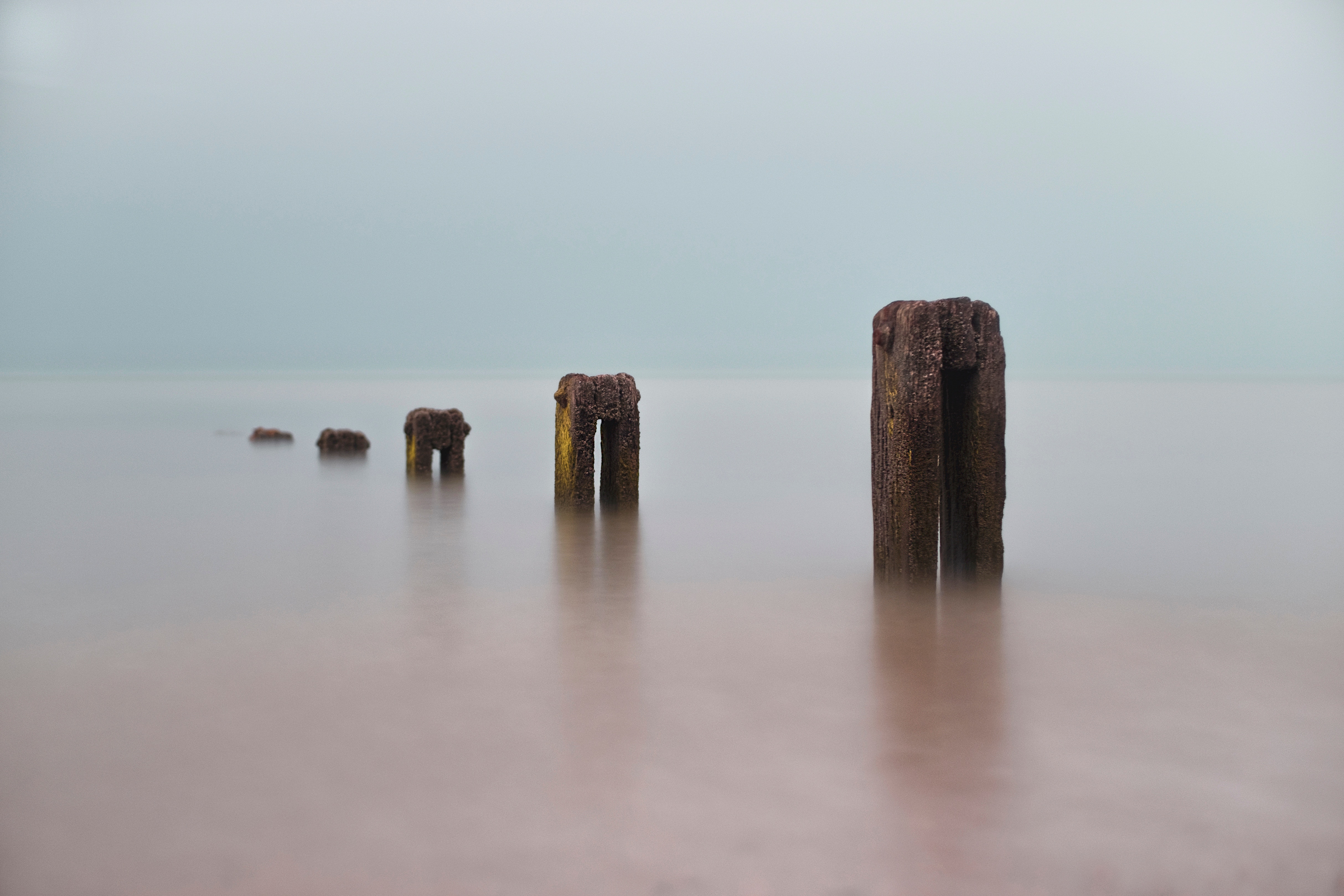 Wooden posts in the sea with long exposure HD Wallpaper
