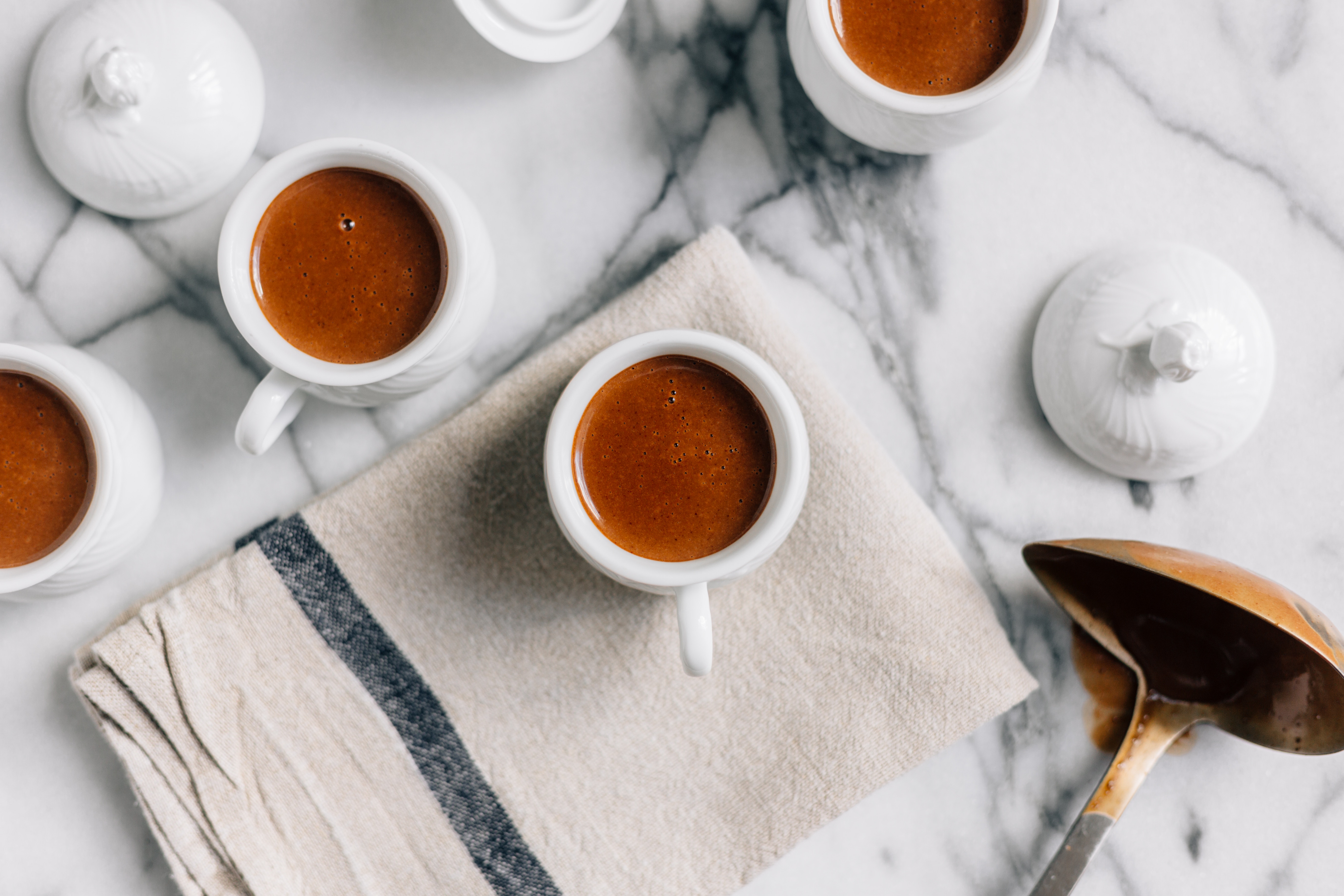 Espresso cups with lids and ladle on marble HD Wallpaper