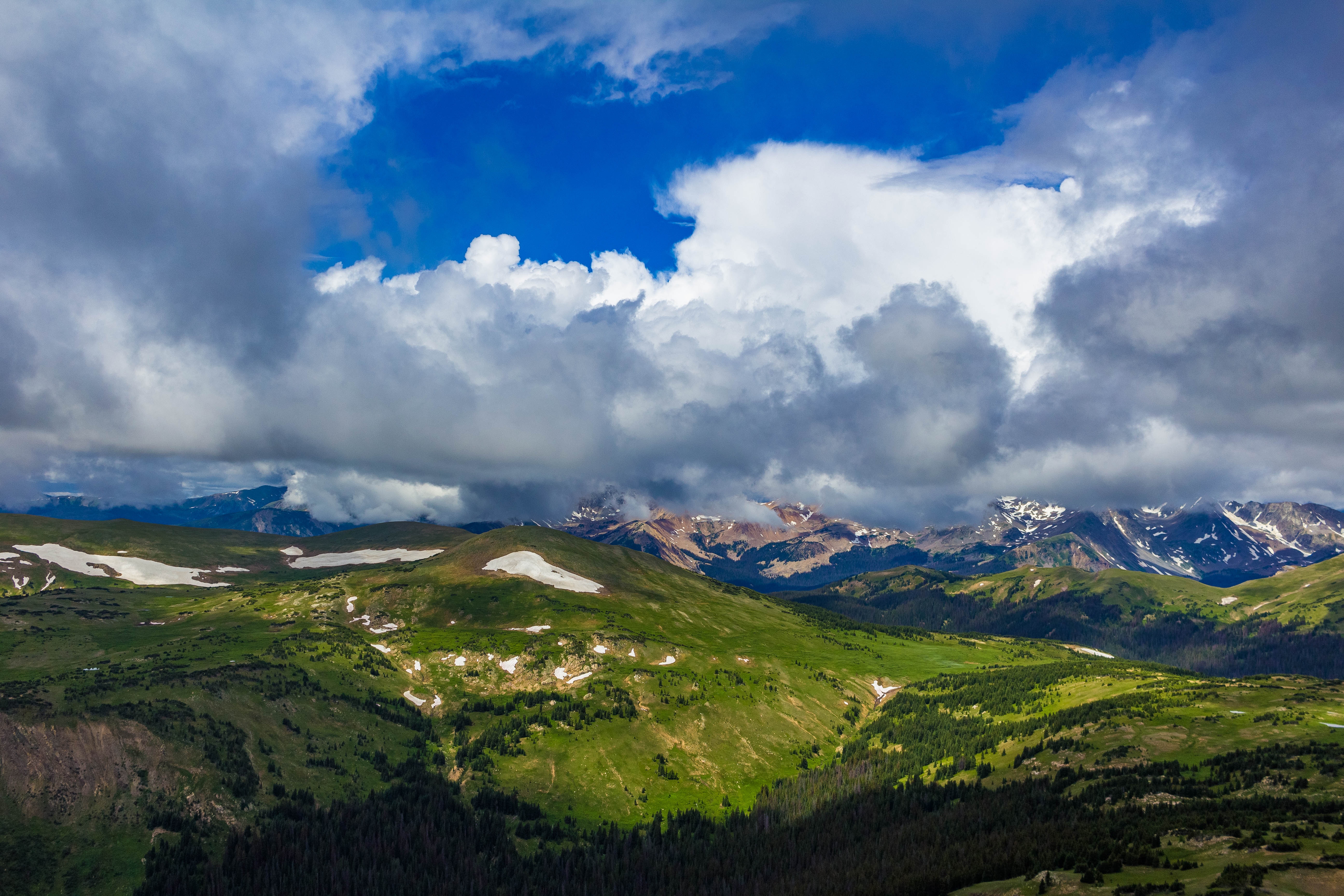 Mountain Range with Green Valley and Cloudy Sky HD Wallpaper