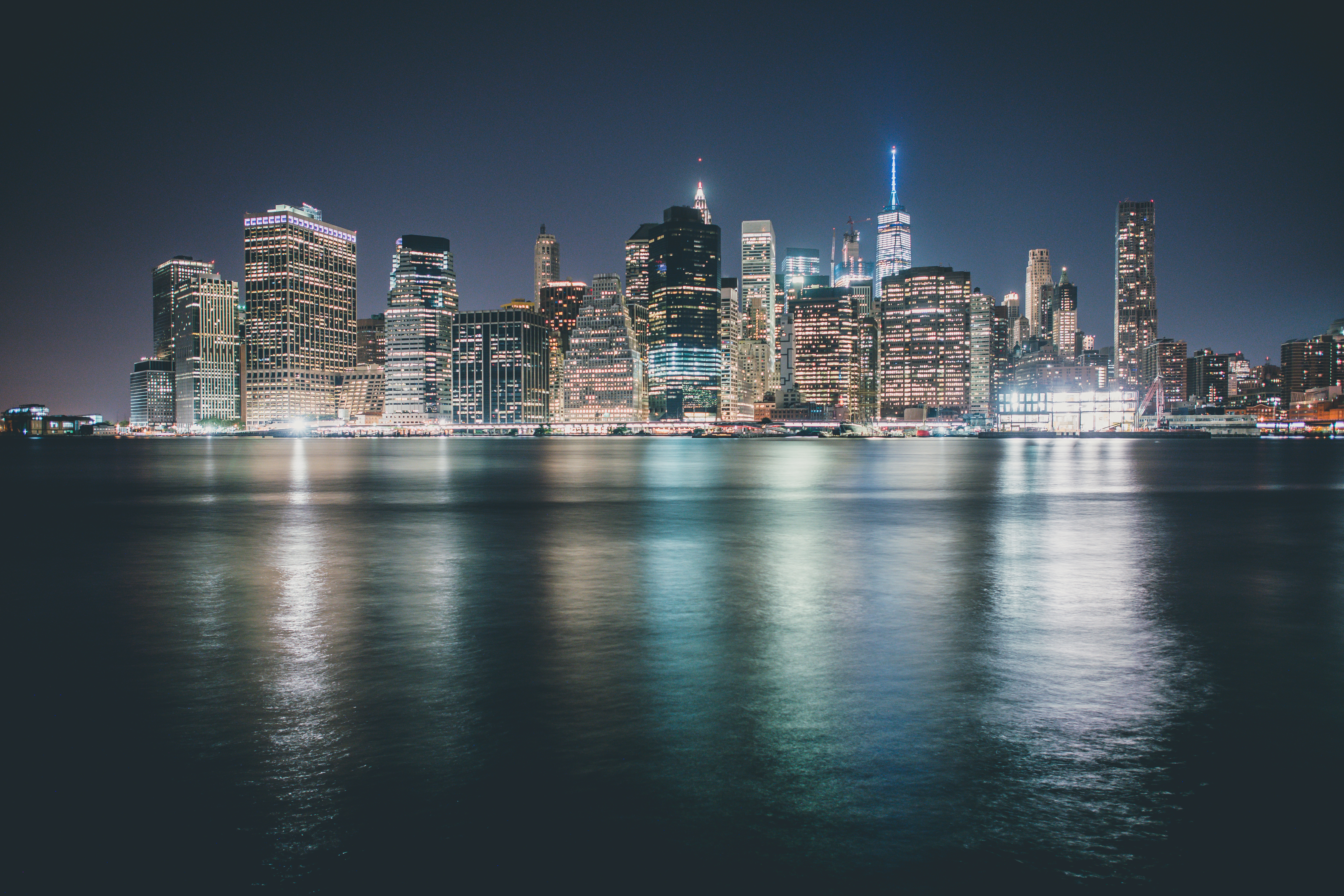 New York City skyline at night with water reflection HD Wallpaper
