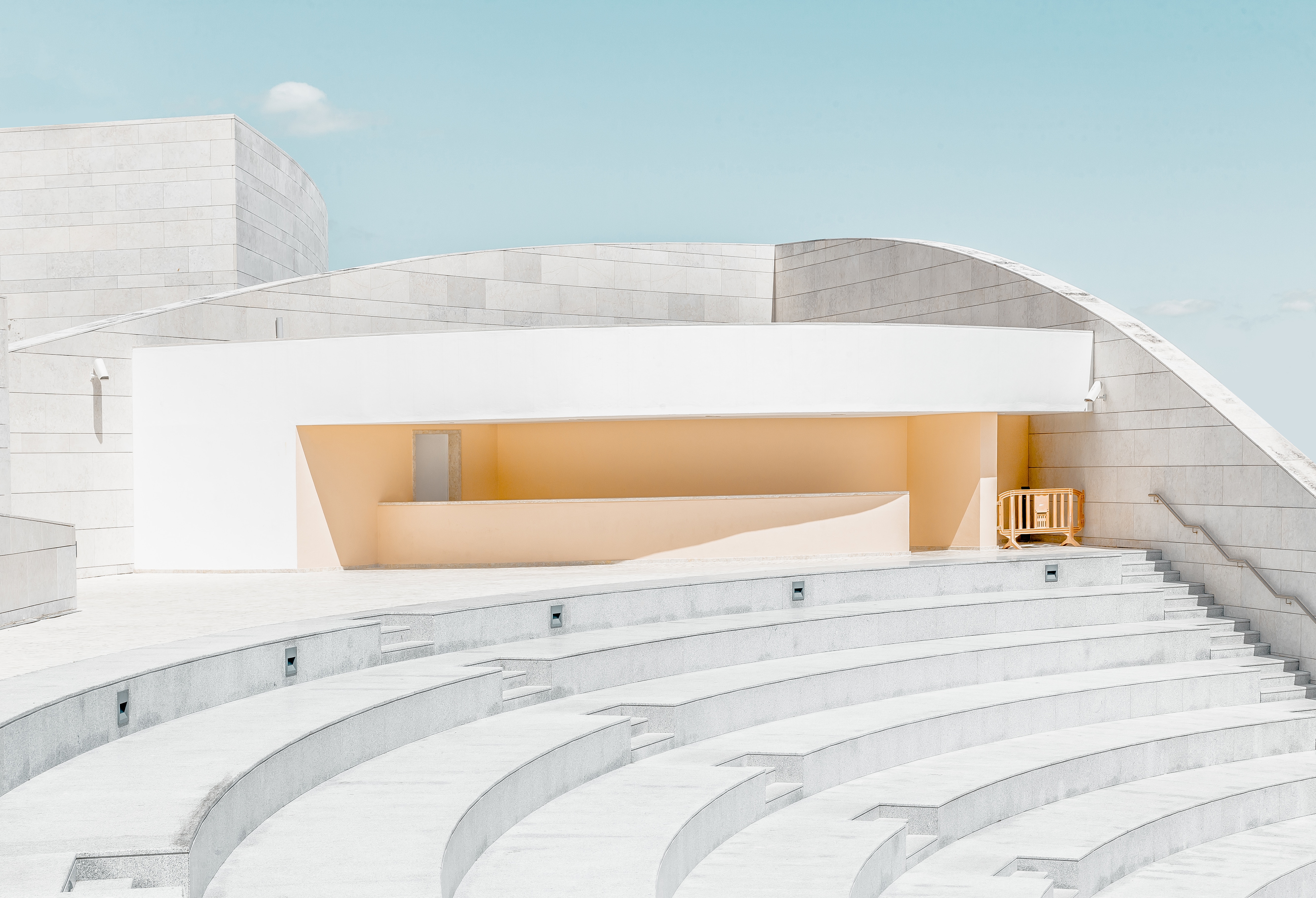 Minimalist architecture with curved concrete steps and yellow accents HD Wallpaper