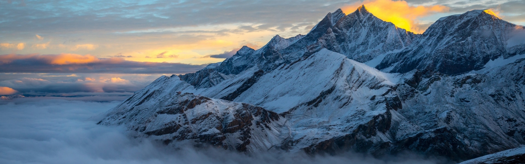 Snowy mountain peaks at sunrise above clouds HD Wallpaper