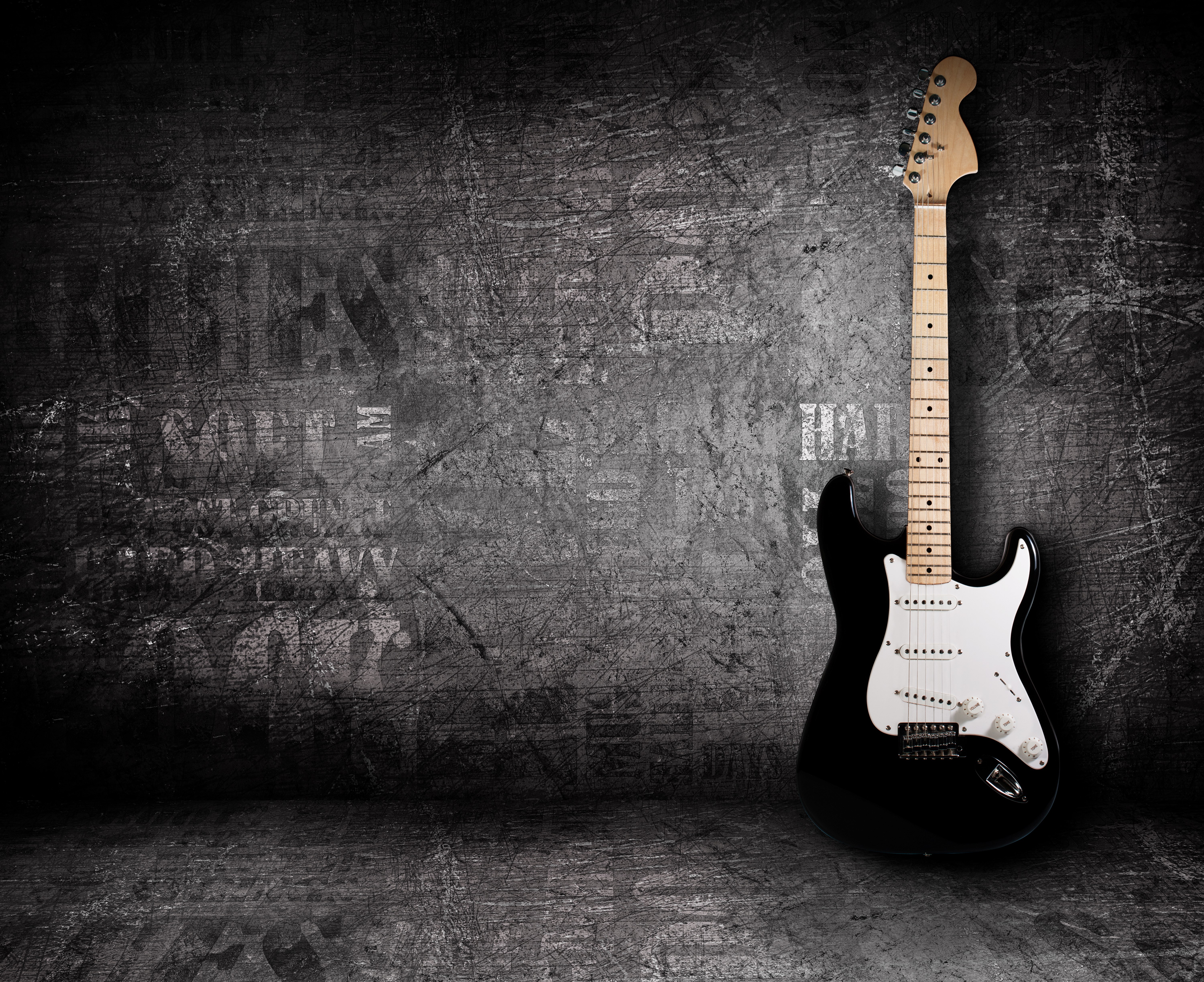 Black electric guitar on a grunge wall HD Wallpaper