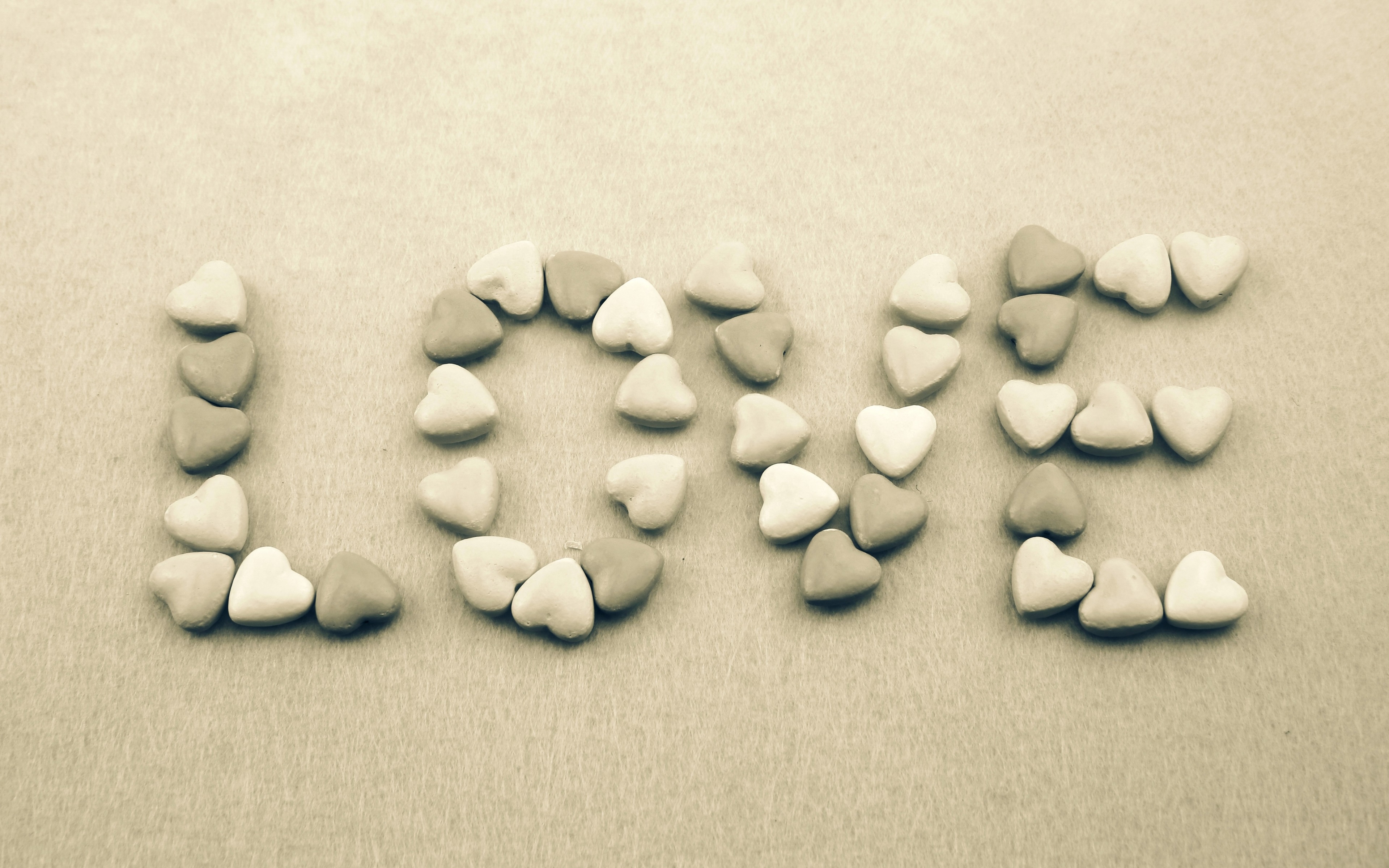The word LOVE spelled with heart candies HD Wallpaper