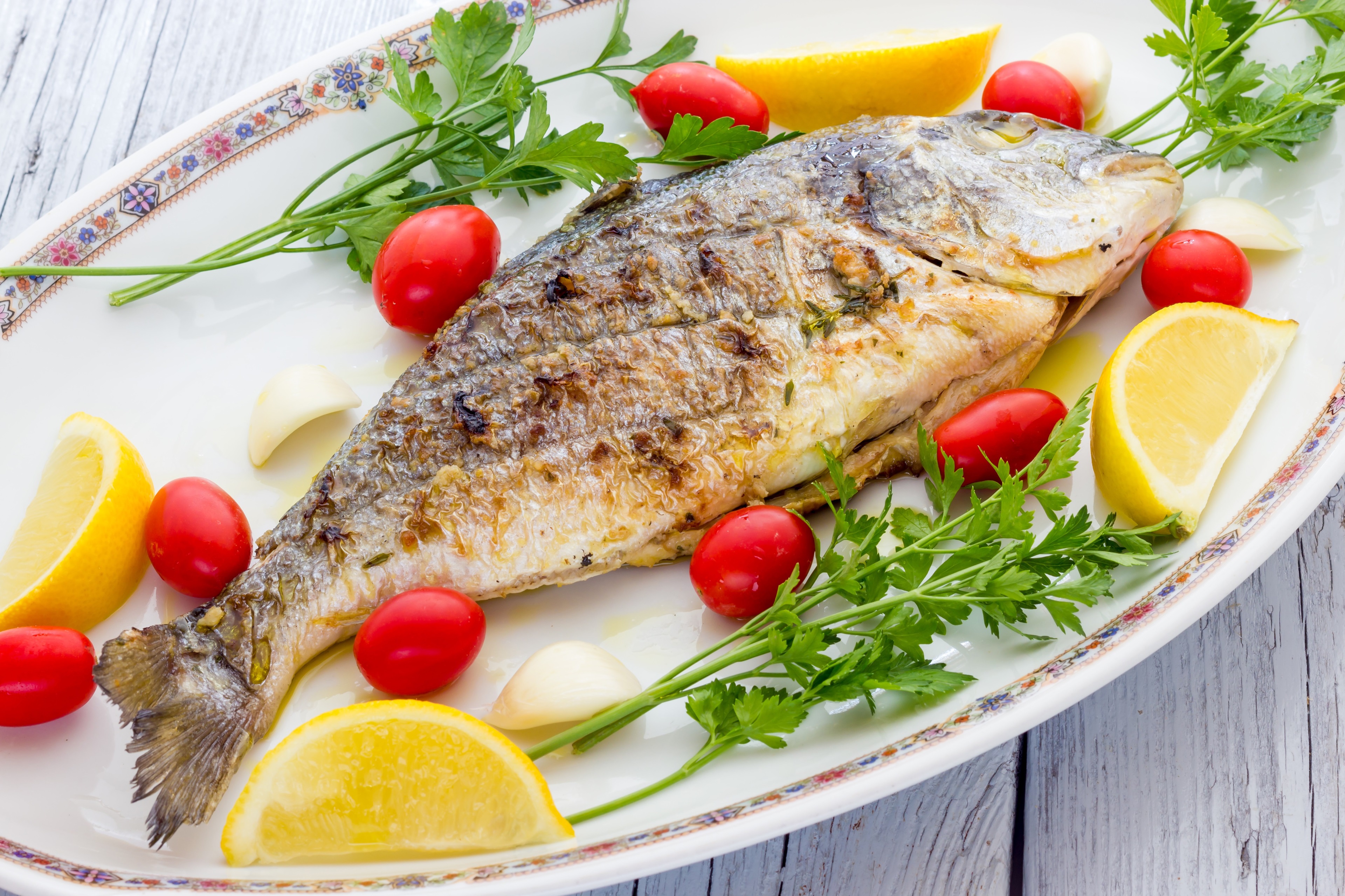 Whole roasted fish with lemon and tomatoes HD Wallpaper