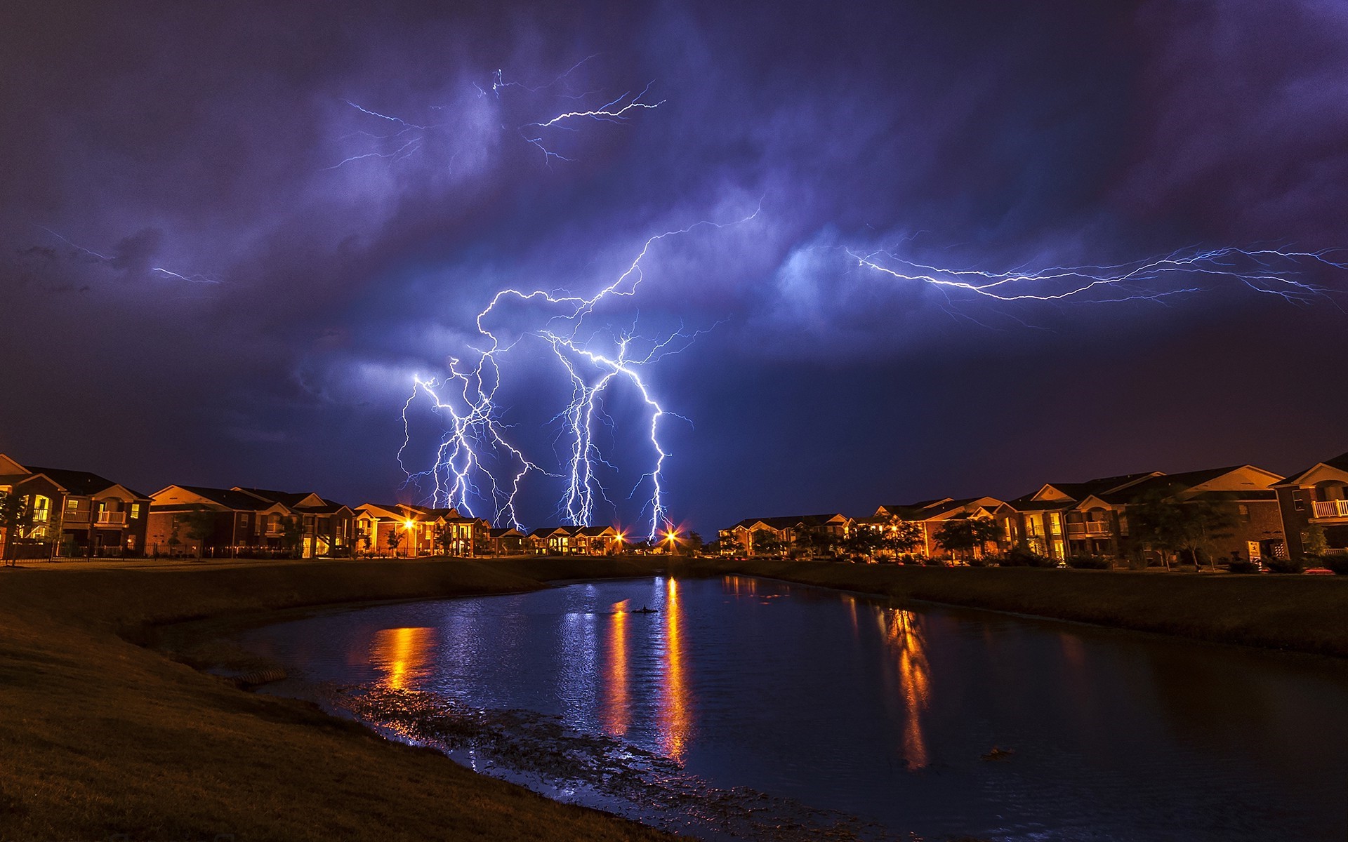 Lightning storm over houses and a lake HD Wallpaper