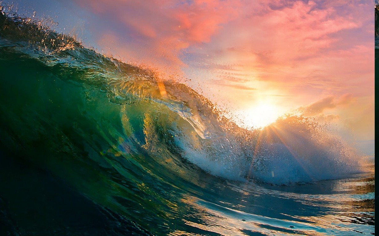 Ocean wave crashing at sunset with sun rays HD Wallpaper