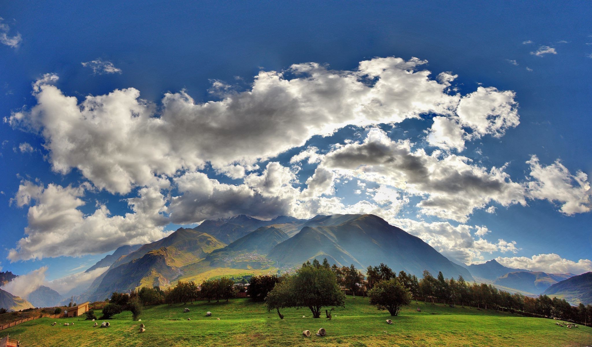 Mountain landscape with clouds and green plains HD Wallpaper