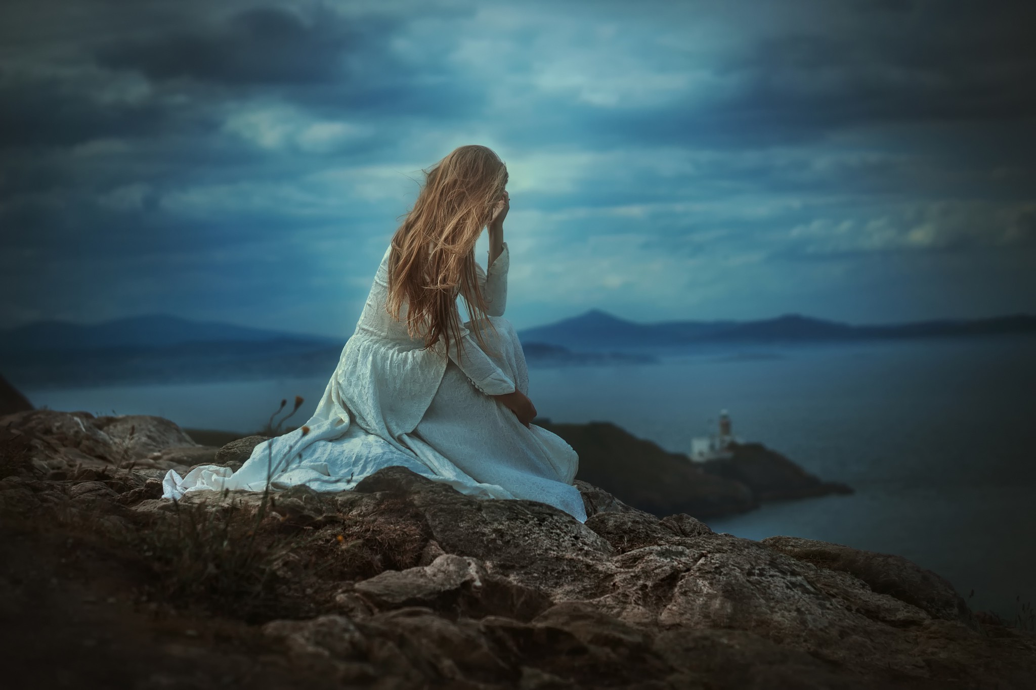 Woman in white dress sitting on rocks overlooking the sea HD Wallpaper