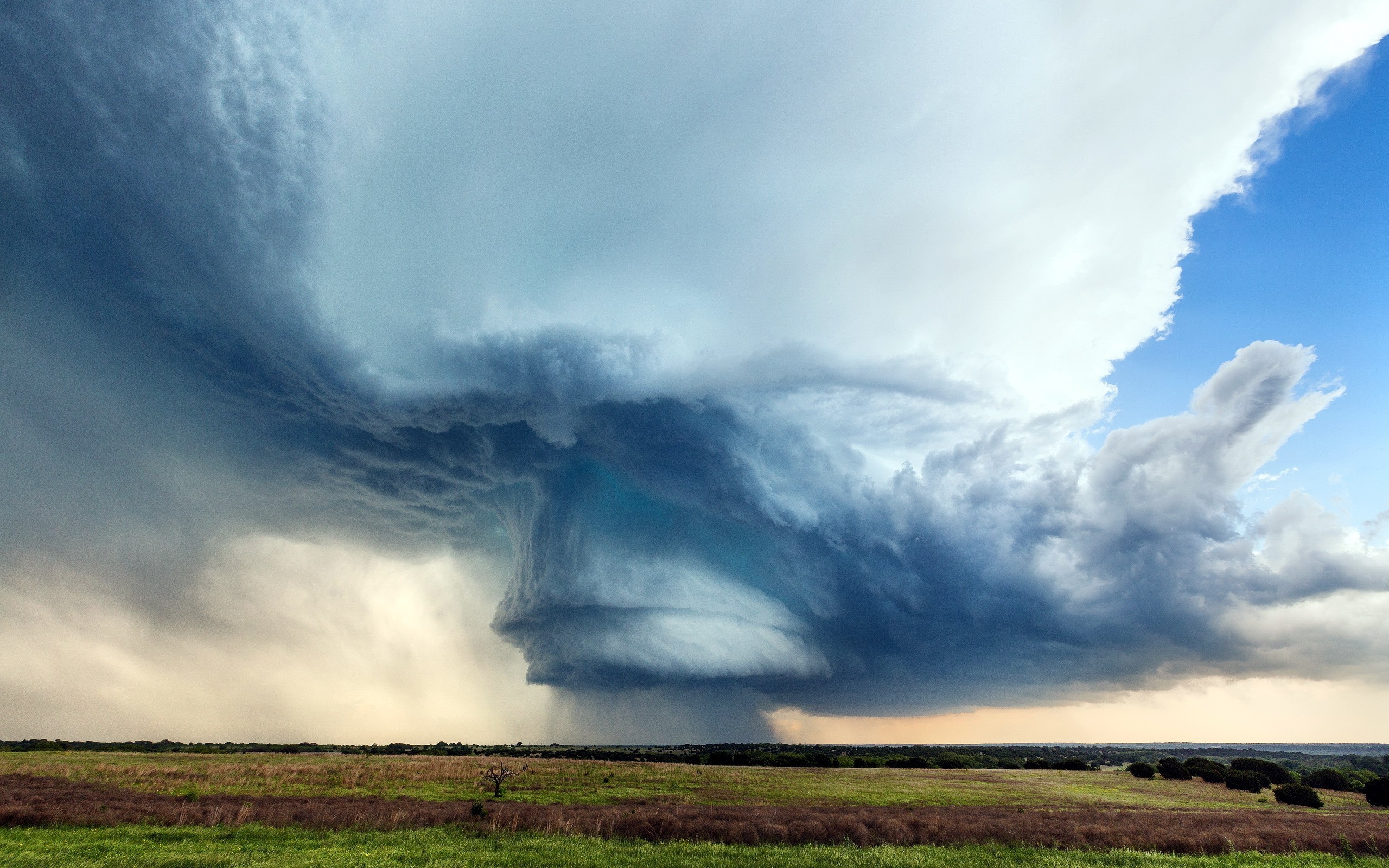 Storm clouds over a grassy field HD Wallpaper
