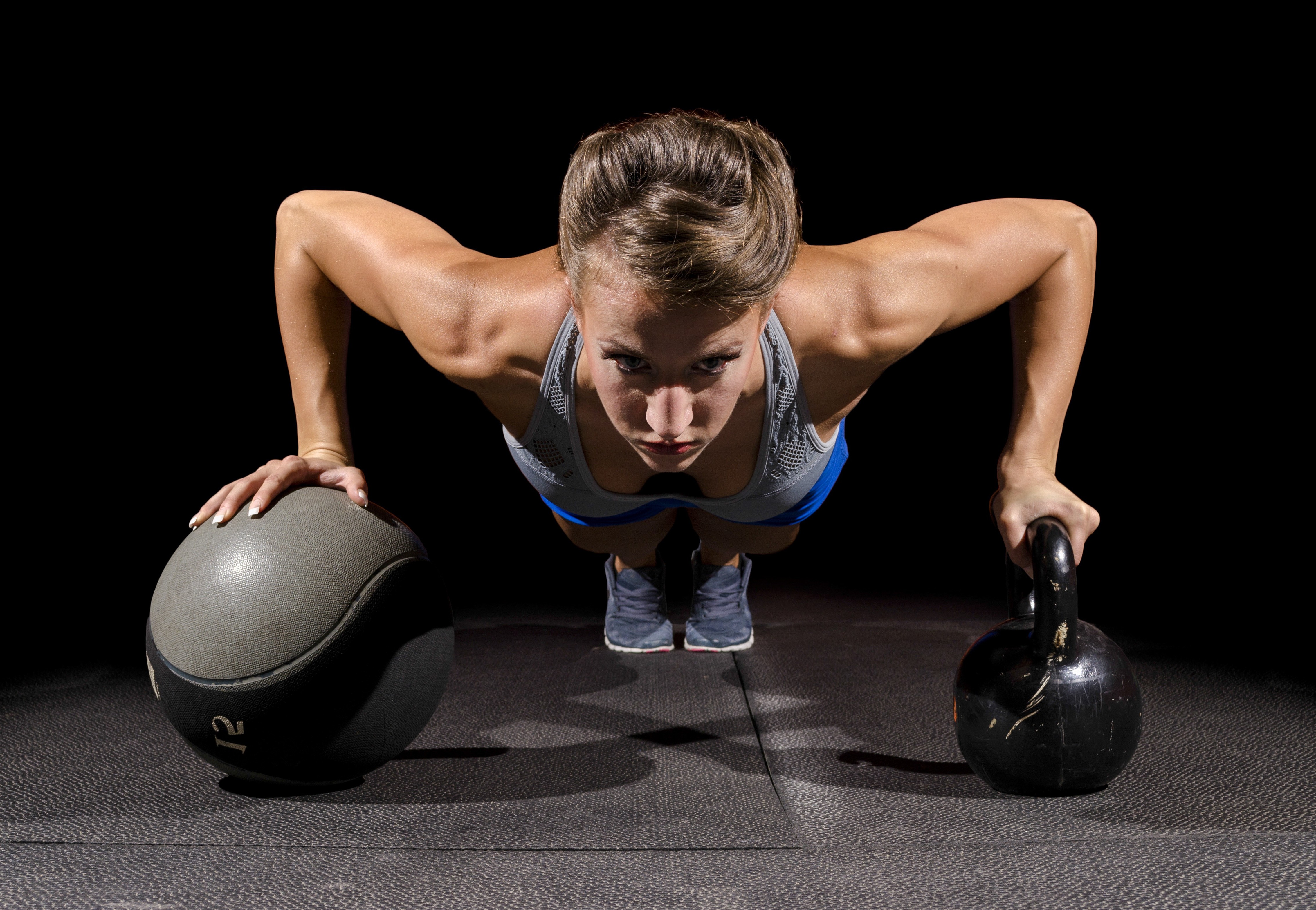 Woman doing push-ups with kettlebell and medicine ball HD Wallpaper