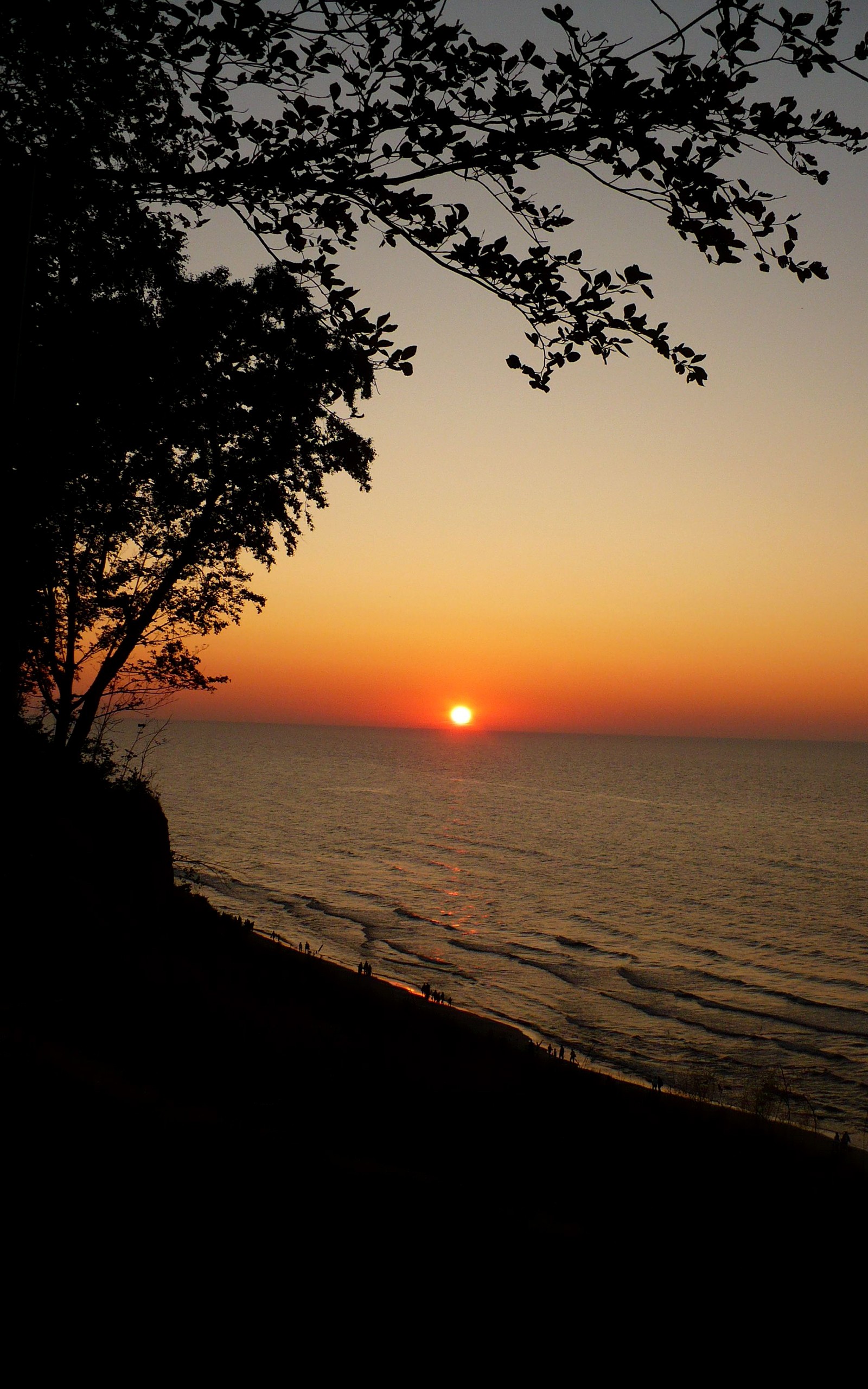 Sunset over the sea with a cliffside beach HD Wallpaper