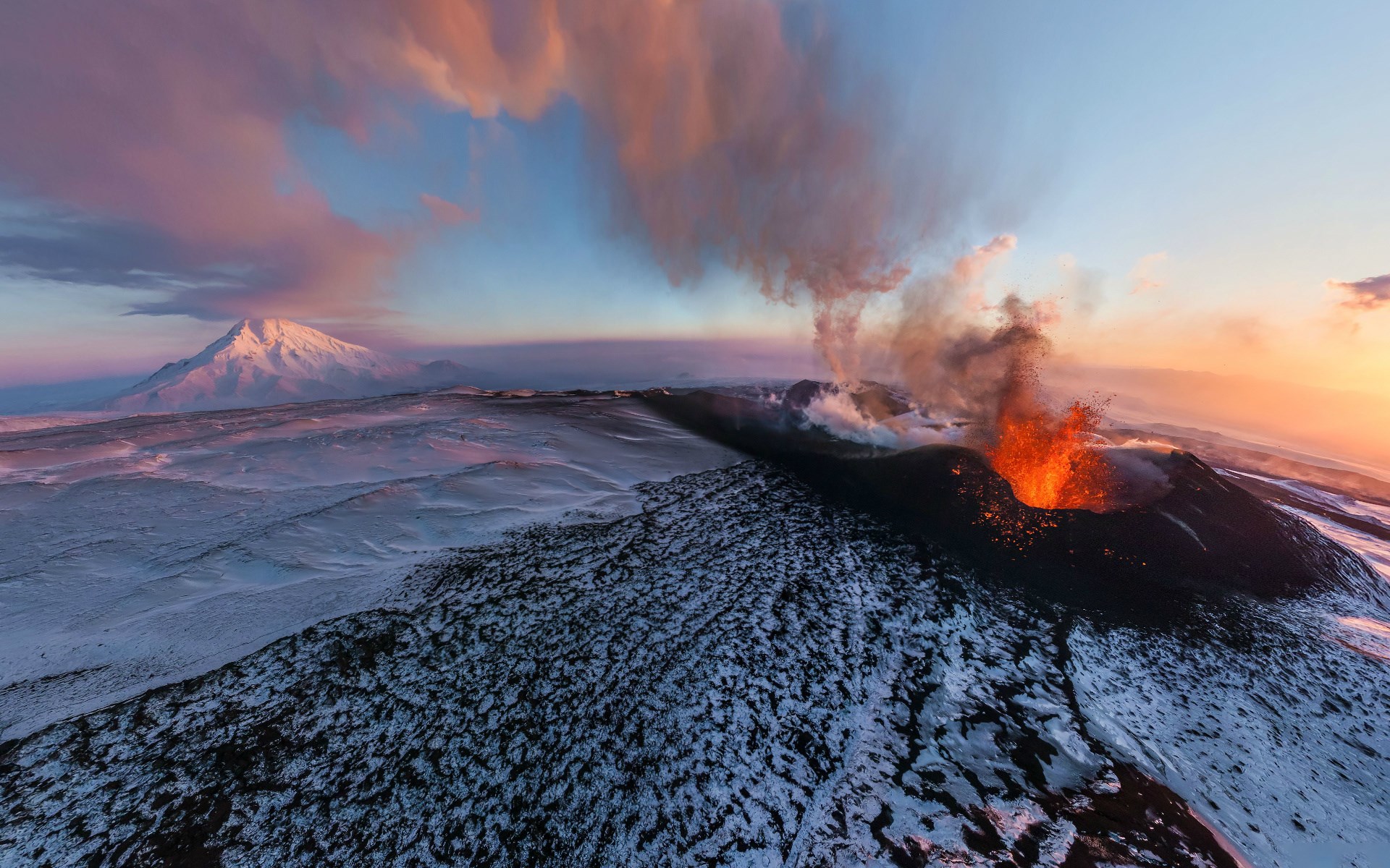 Volcano erupting with lava and smoke in a snowy landscape HD Wallpaper