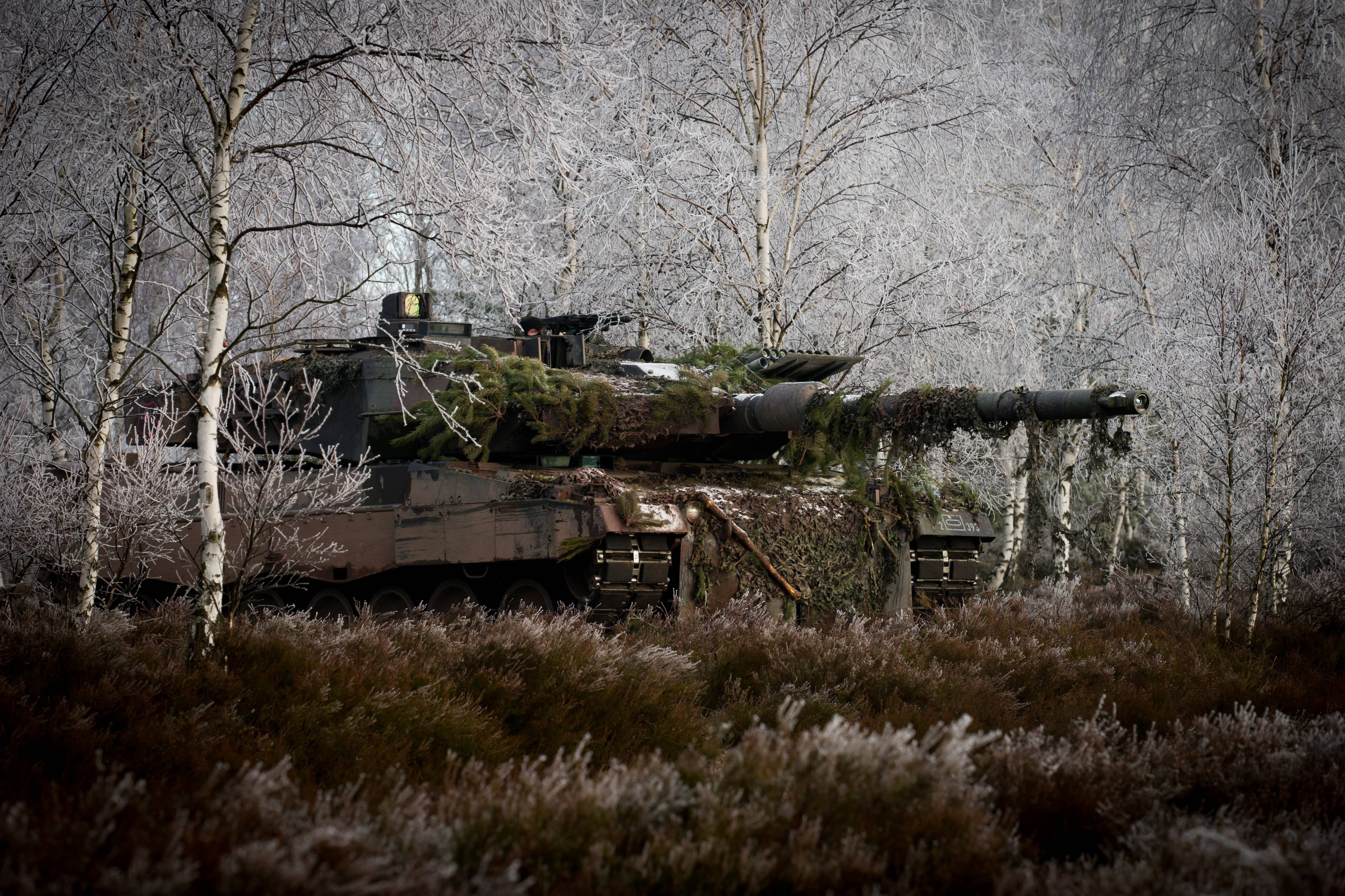 Leopard 2 tank camouflaged in a frosty forest HD Wallpaper