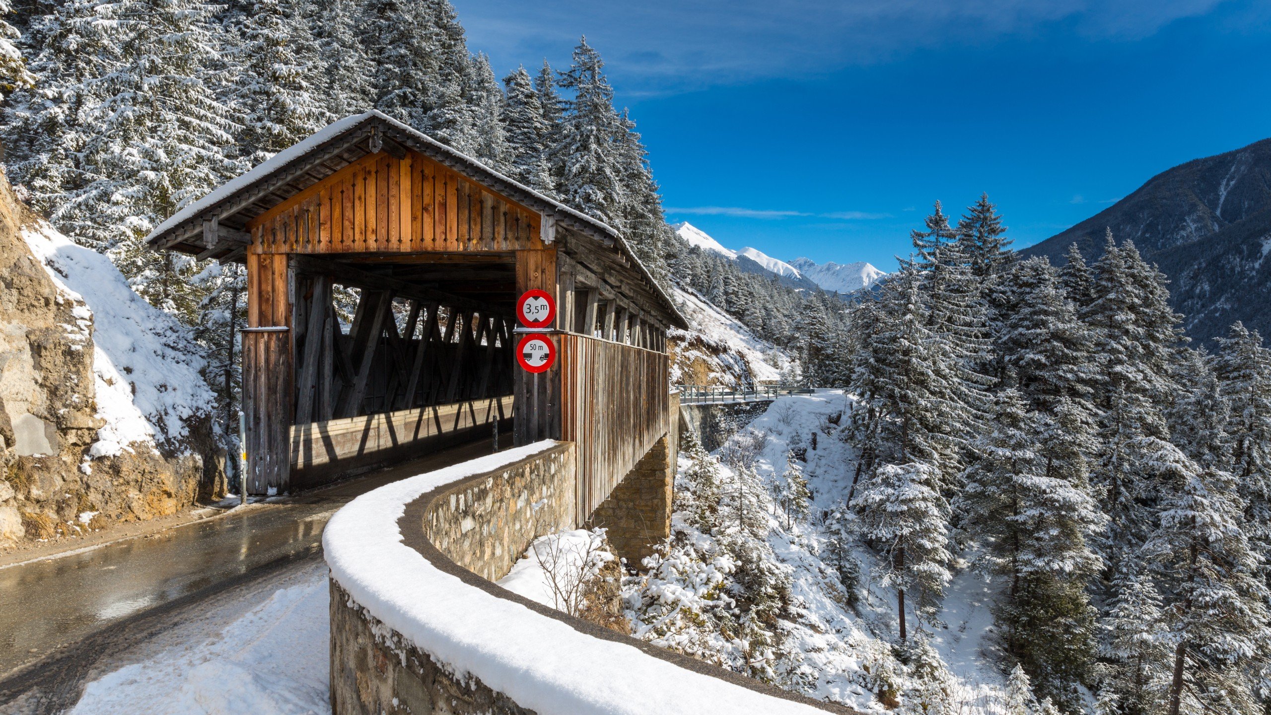 Covered wooden bridge in snowy Swiss Alps HD Wallpaper