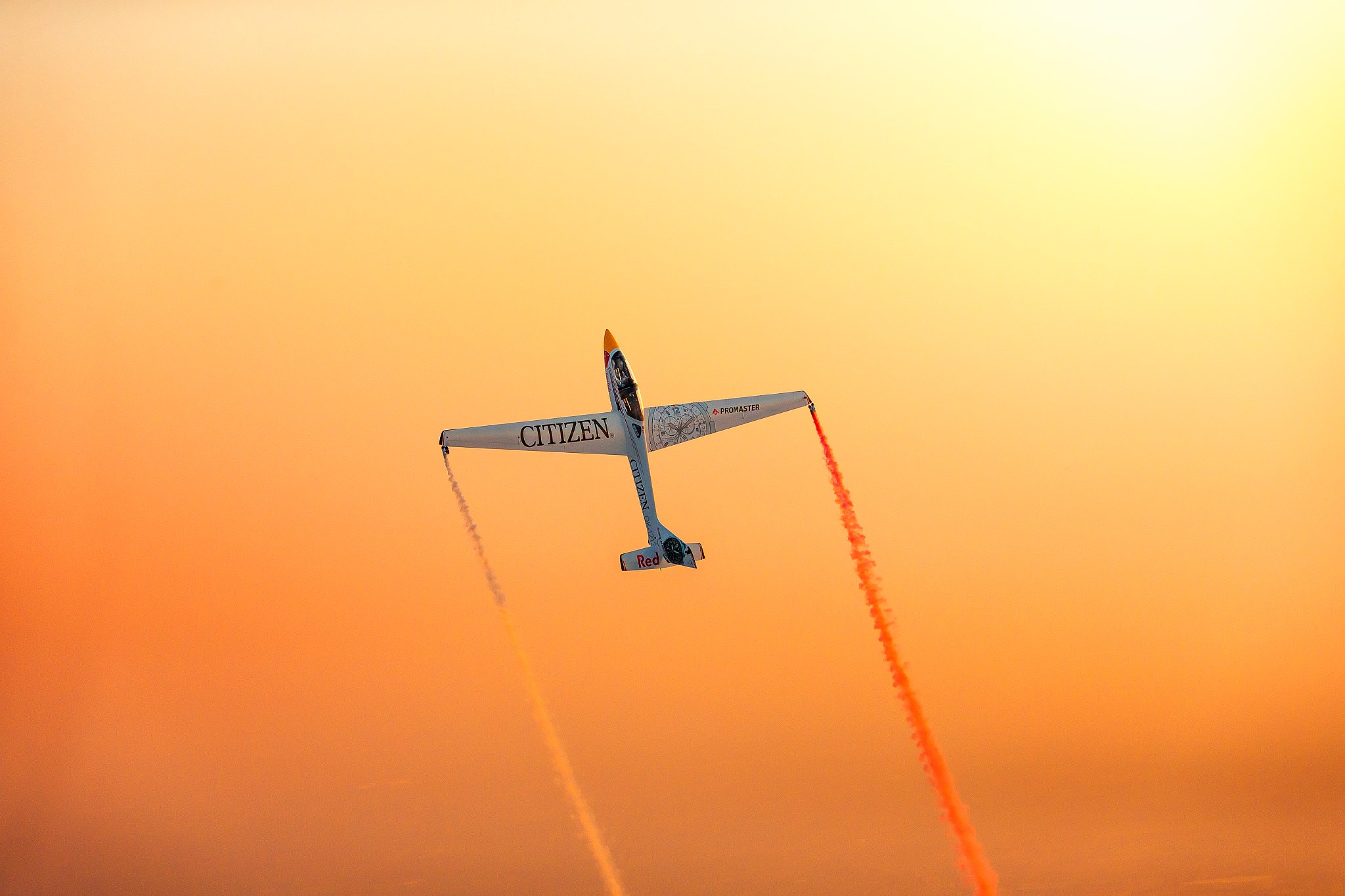 Airplane performing aerobatics with orange smoke HD Wallpaper