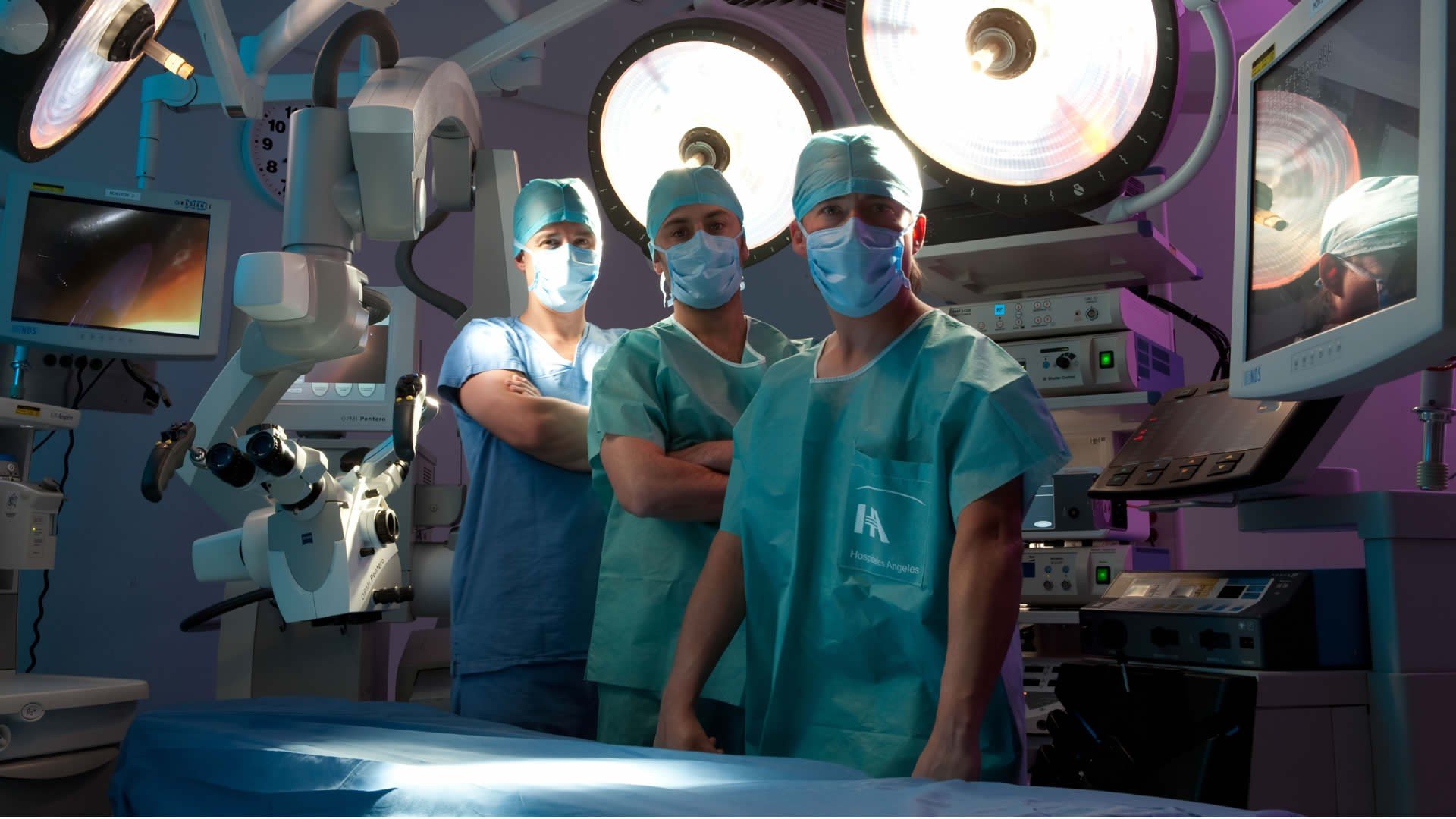 Three surgeons in a modern operating room HD Wallpaper
