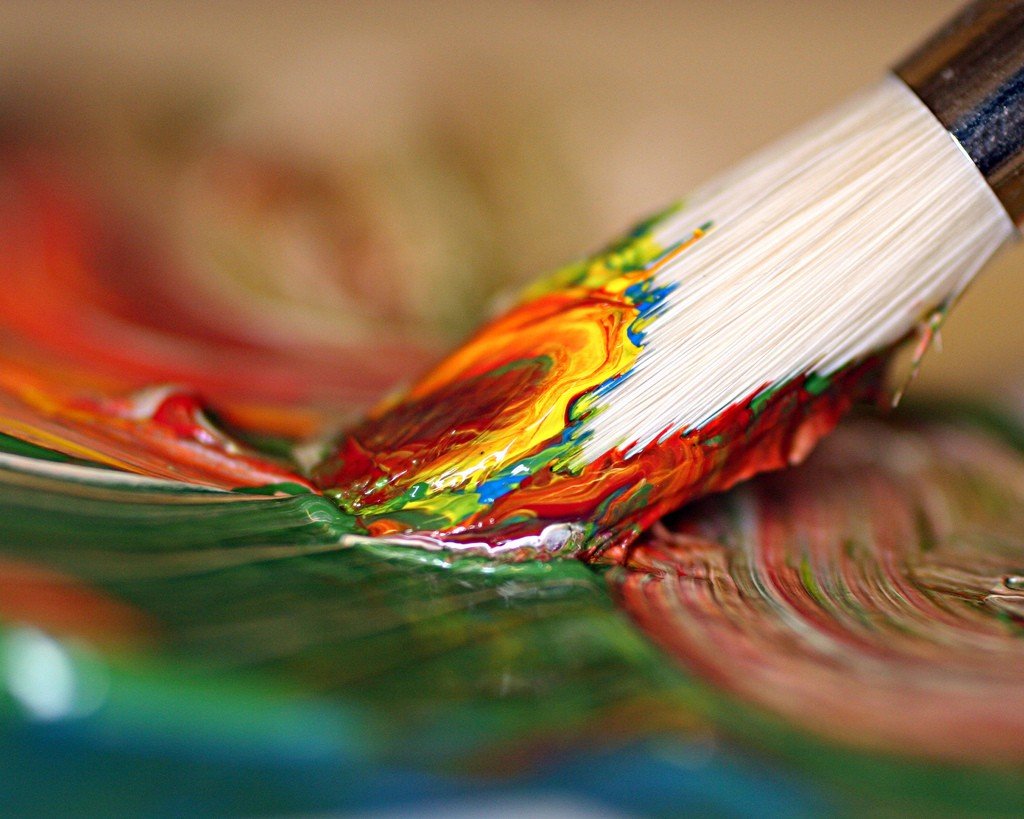 Paintbrush mixing colorful paints on a palette HD Wallpaper