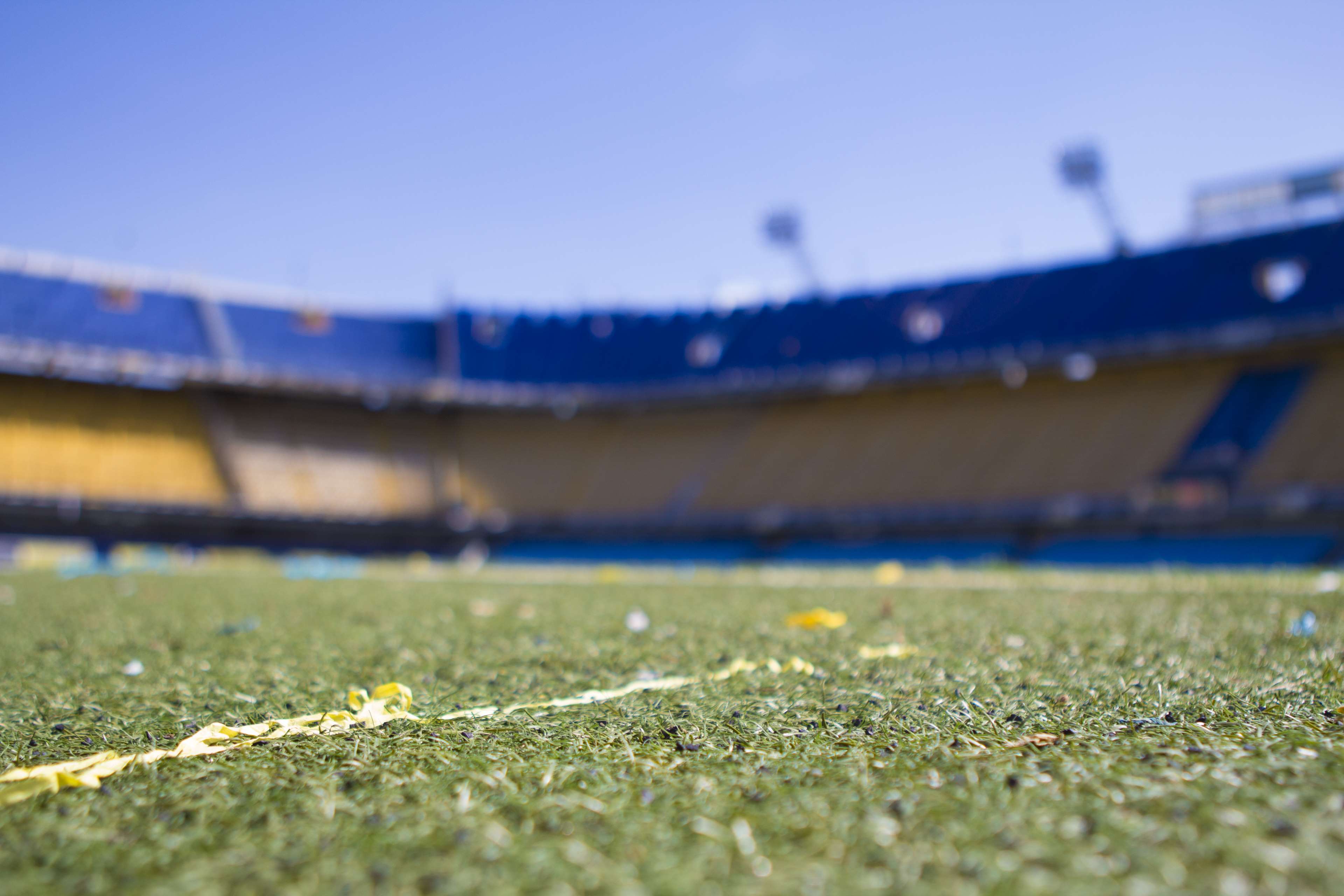 Soccer stadium field with confetti and blue sky HD Wallpaper