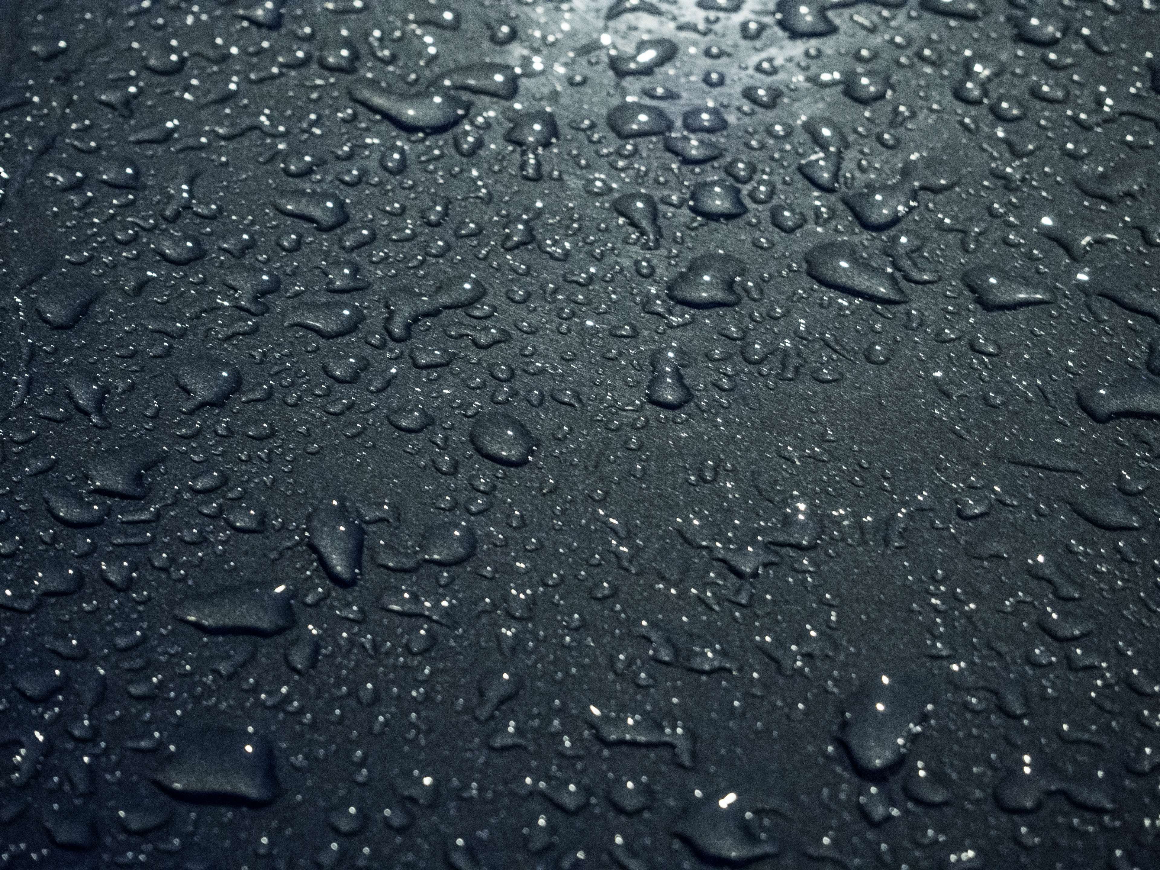Close up of water droplets on a dark surface HD Wallpaper