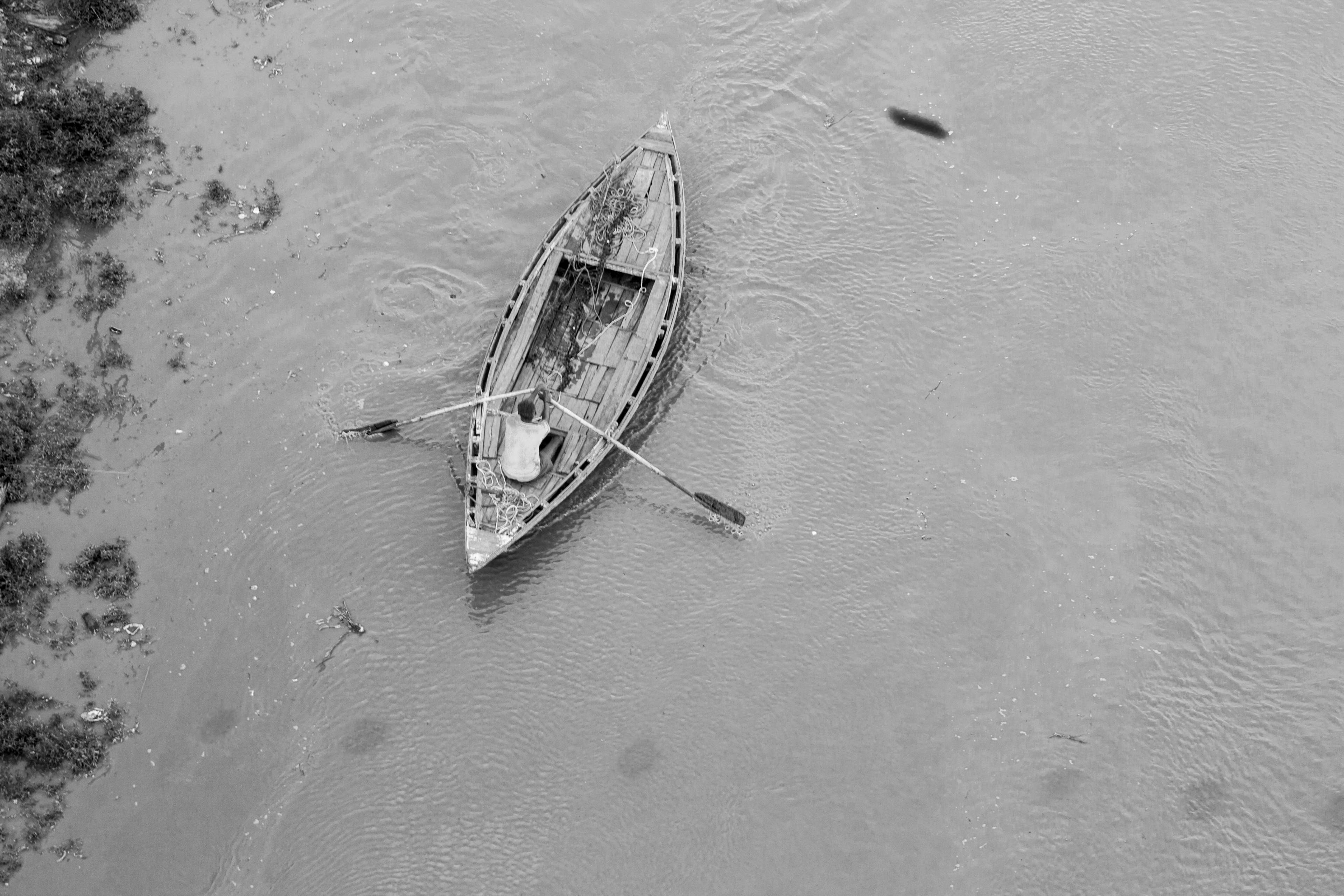 Man rowing a boat on the Ganges River in Varanasi HD Wallpaper