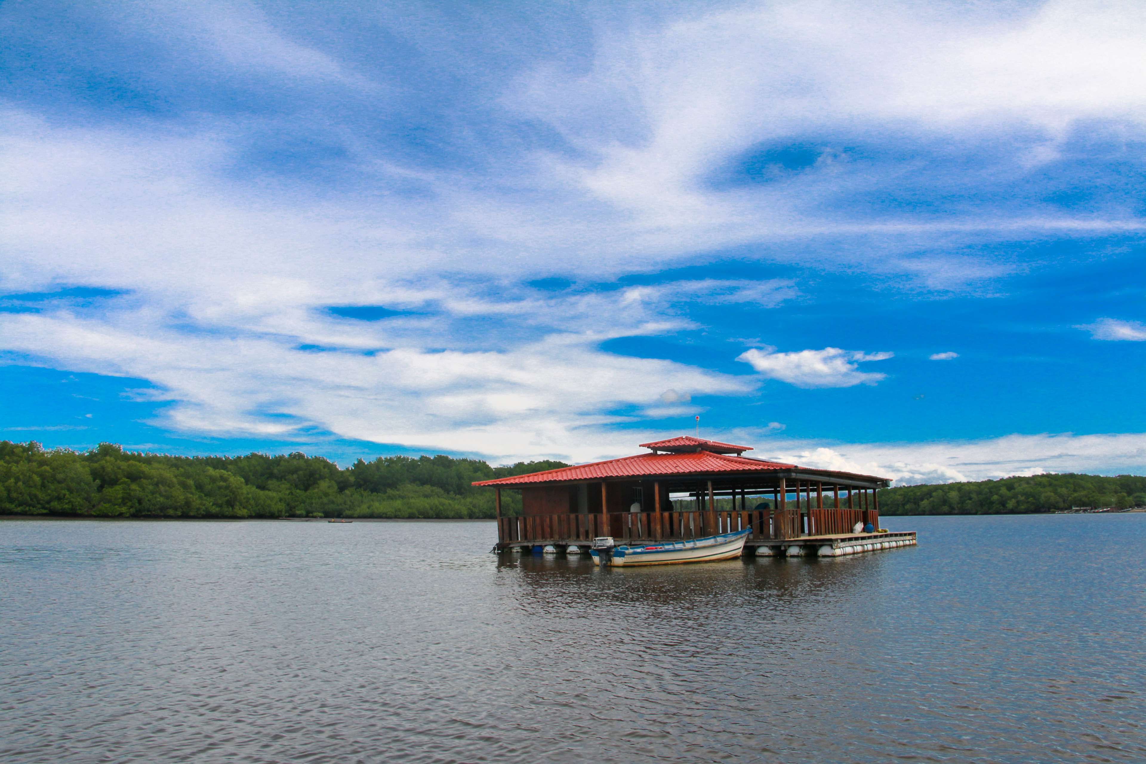 Floating wooden cabana with red roof on a lake HD Wallpaper