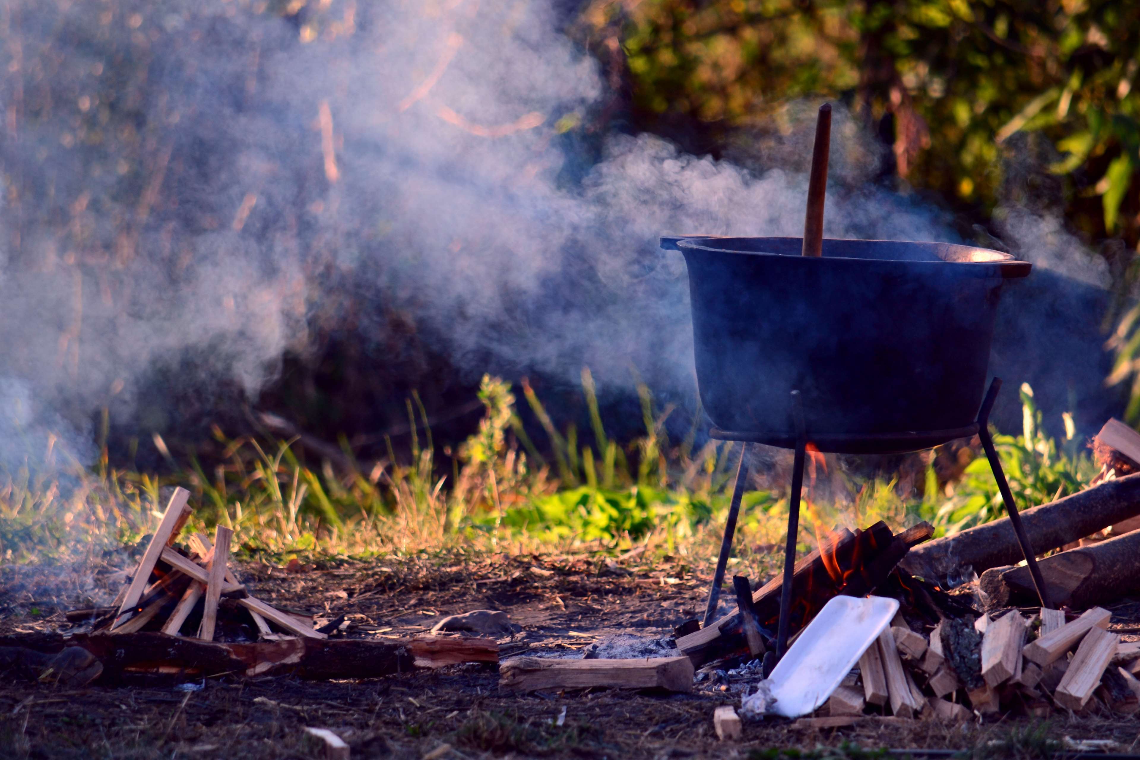 Cauldron cooking over a campfire with smoke HD Wallpaper