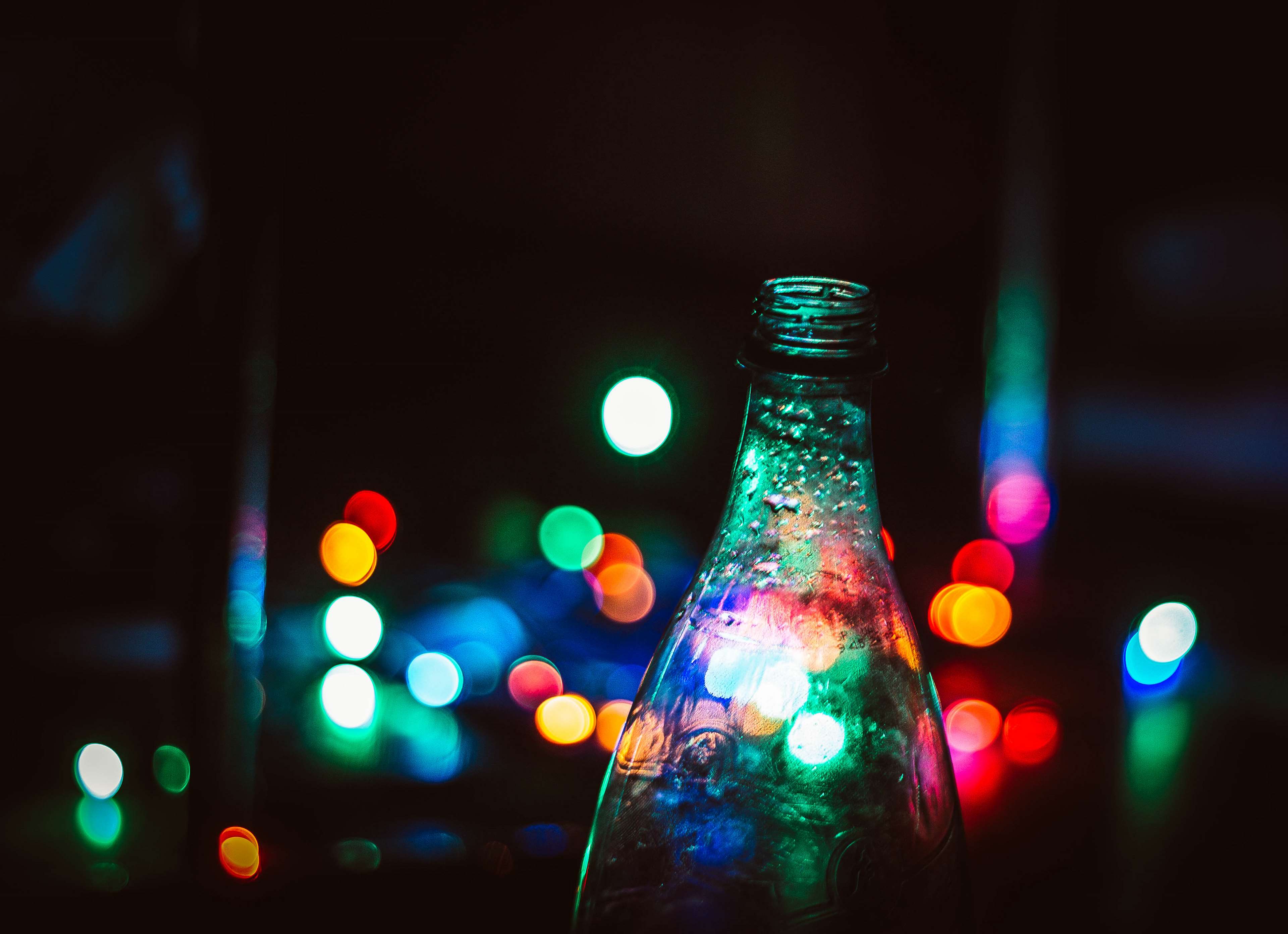 Glass bottle with colorful bokeh lights at night HD Wallpaper