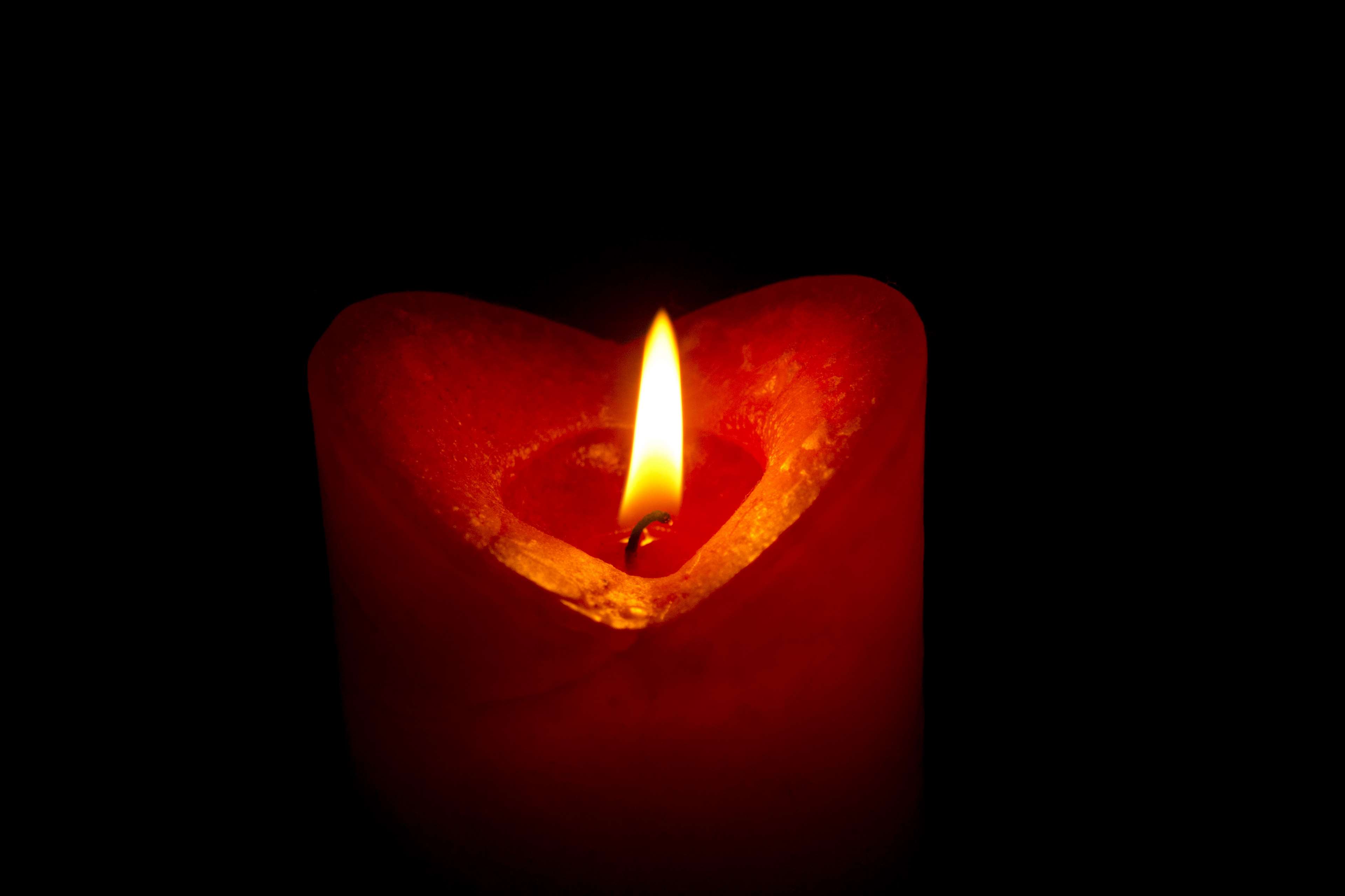 Red heart-shaped candle with a lit flame HD Wallpaper