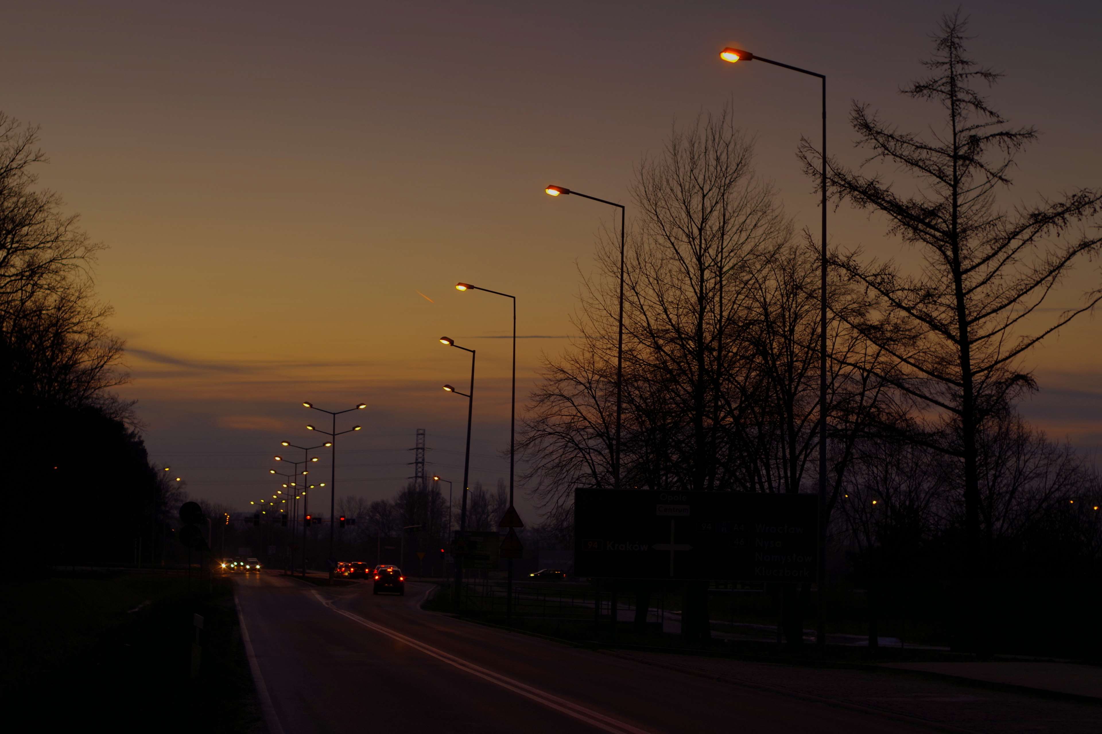 Evening Street with Lit Lamp Posts and Cars 4K HD Wallpaper