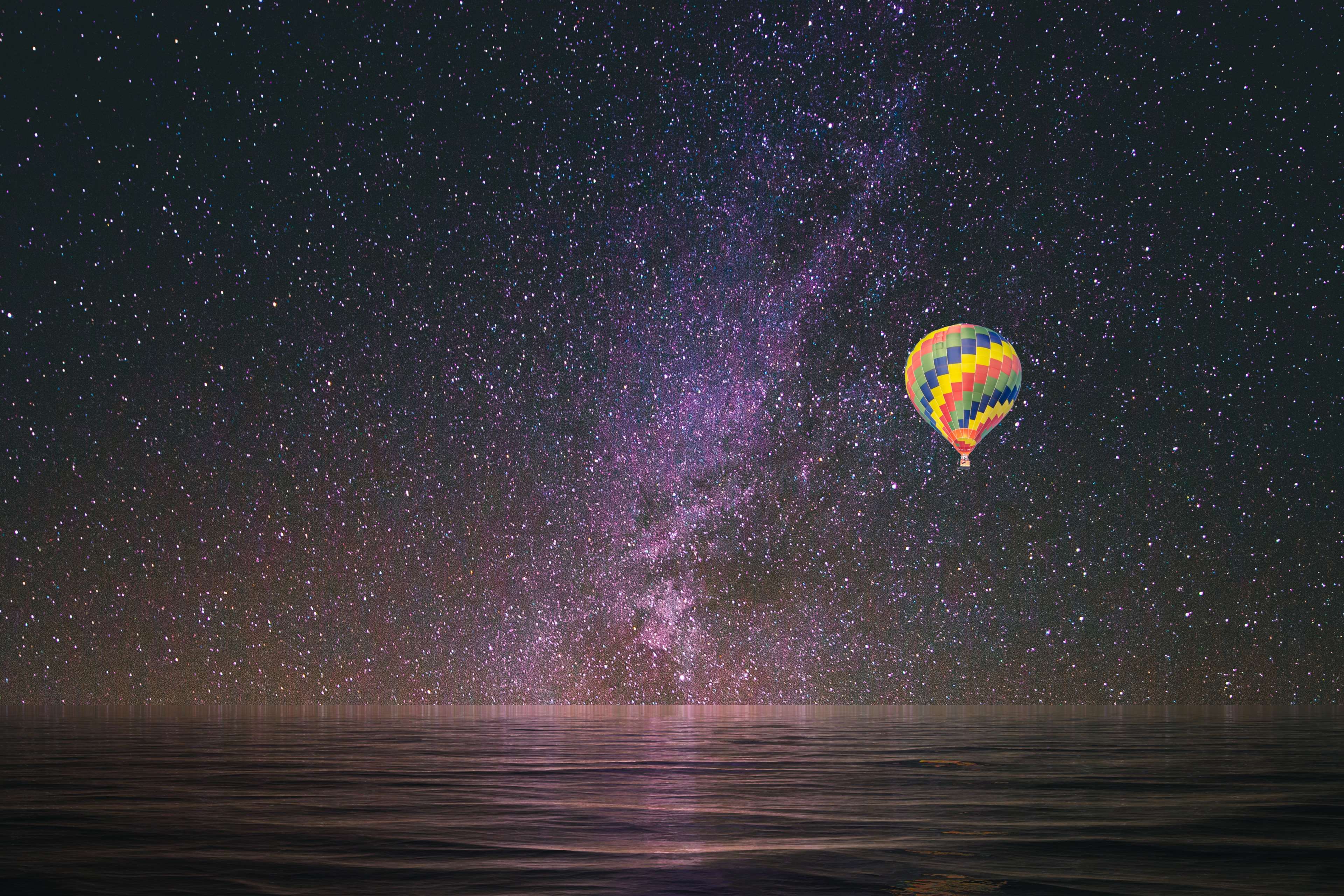 Hot air balloon flying under the Milky Way HD Wallpaper