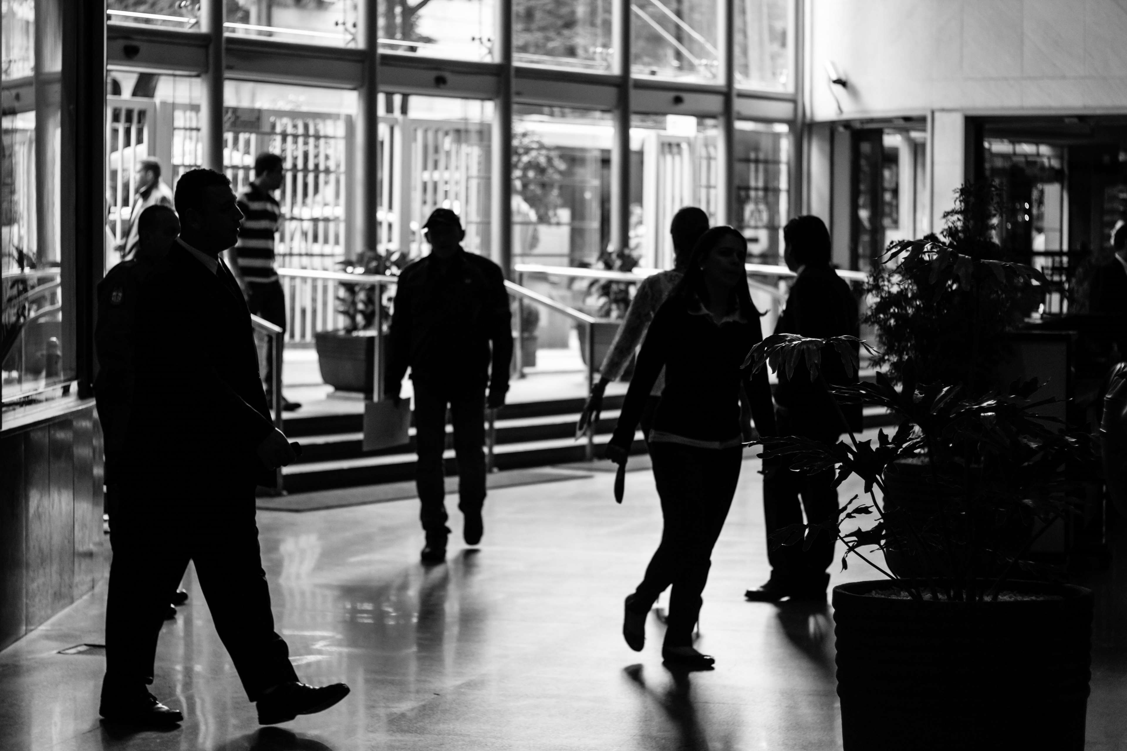 People walking in a modern building lobby HD Wallpaper