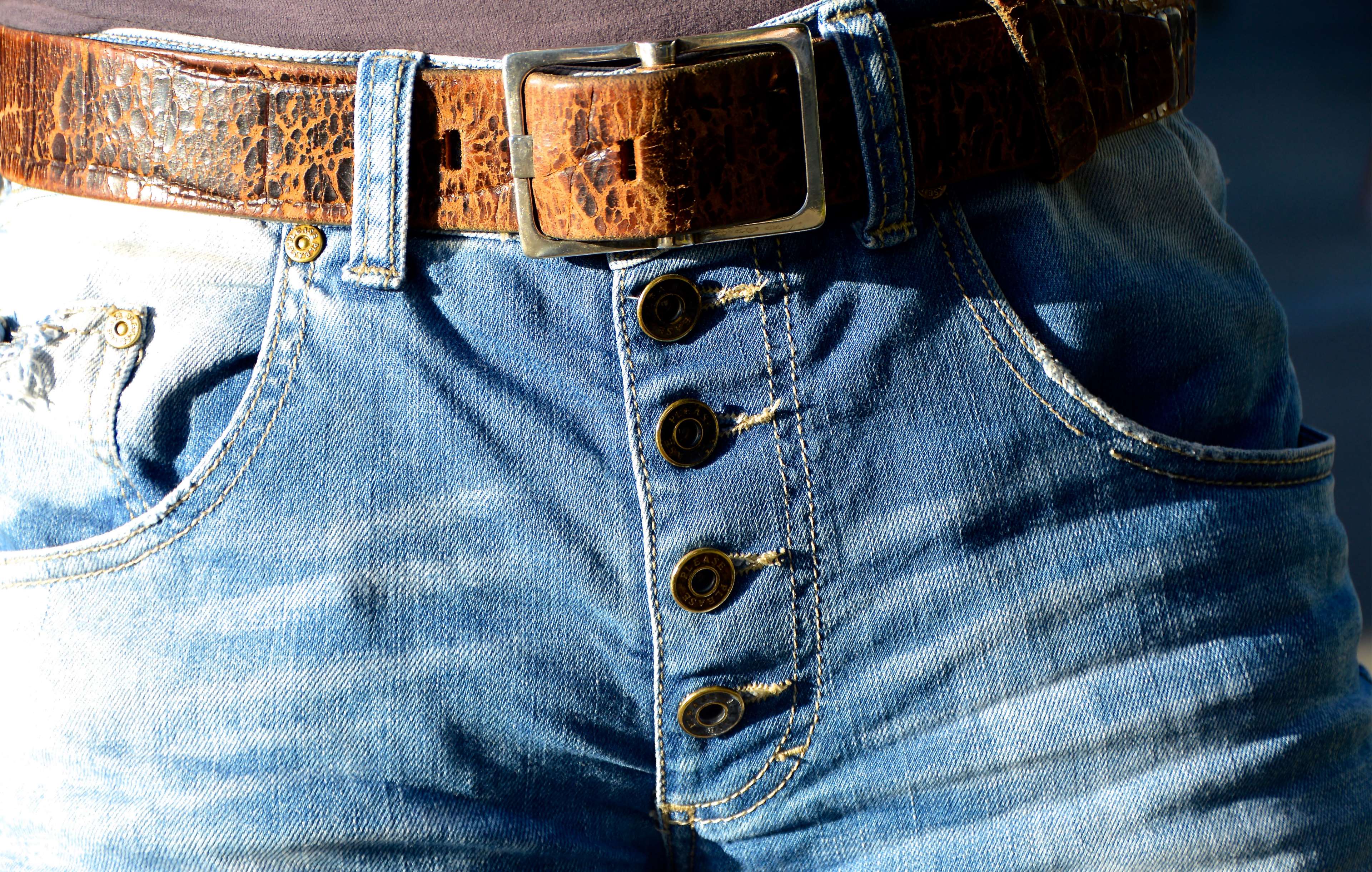 Close up of denim jeans with a leather belt HD Wallpaper