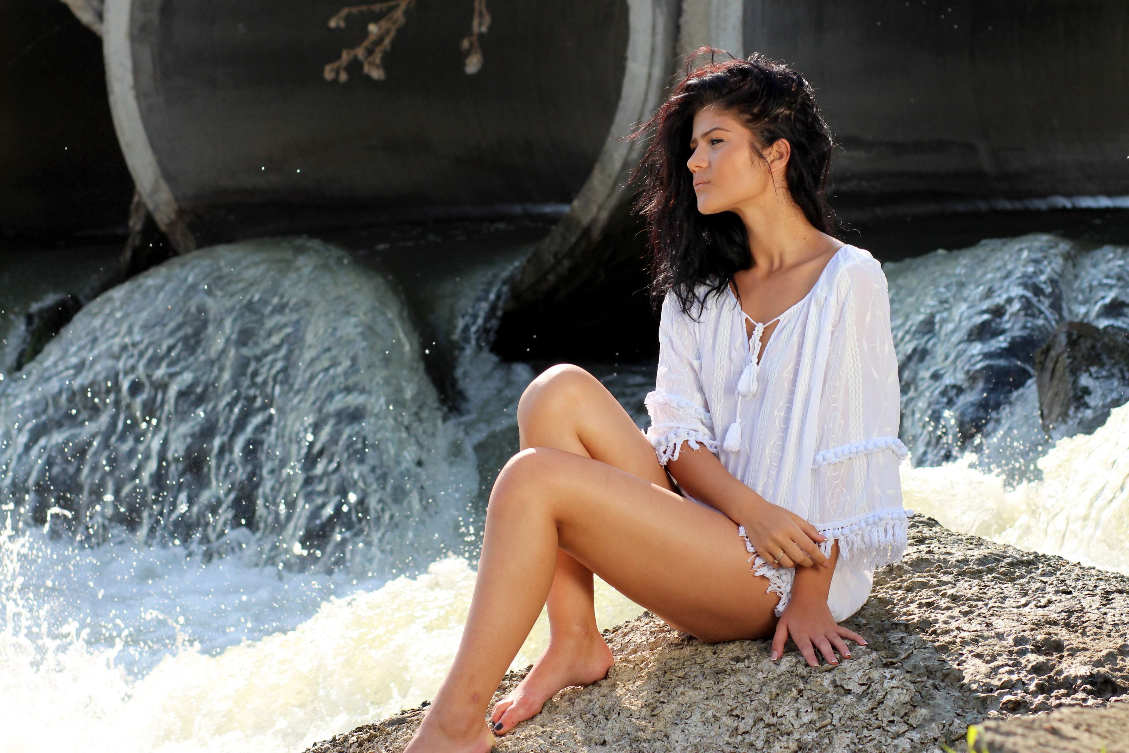 Woman in white shirt sitting by water HD Wallpaper