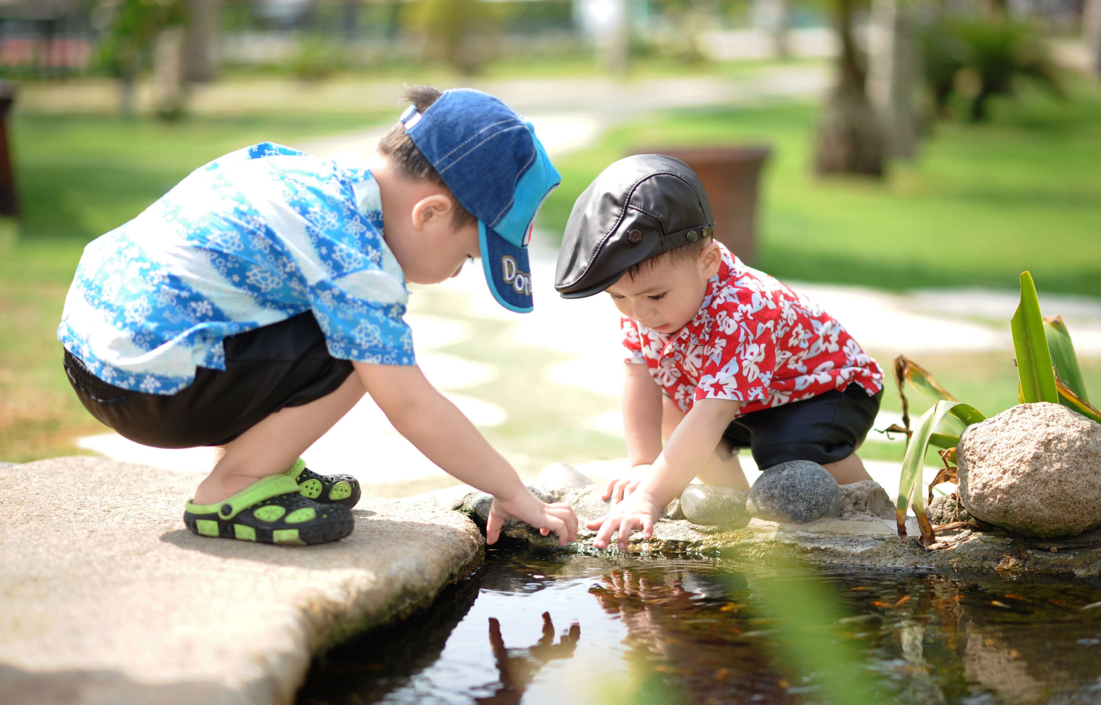 Two young boys playing by the water HD Wallpaper